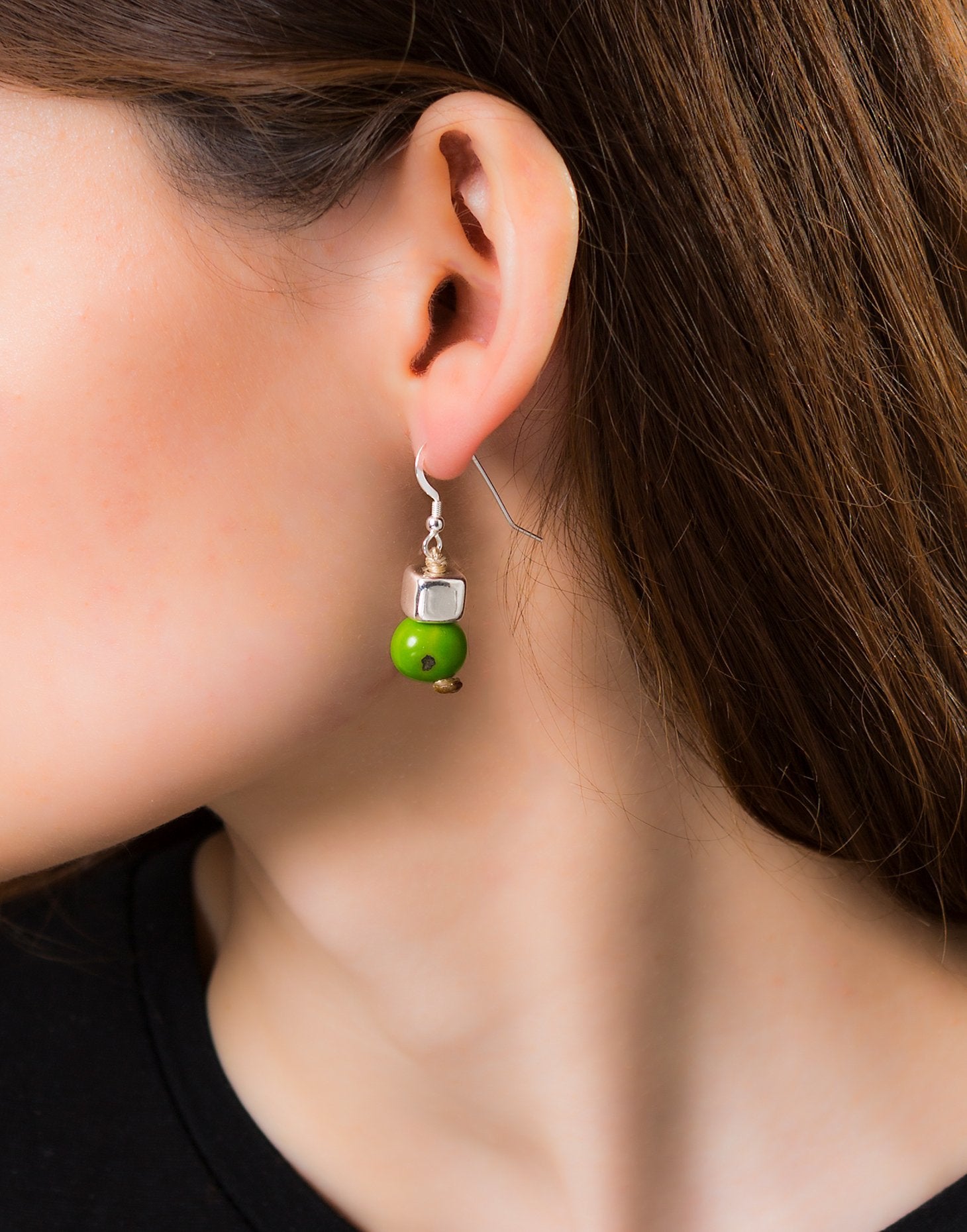 A pair of vibrant Acai Berry Earrings featuring pearl-sized acai seeds and silver accents, elegantly displayed in an eco-friendly bag.