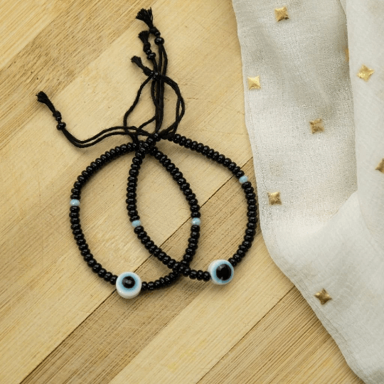 Adjustable black beads bracelet featuring an evil eye charm, combining boho and chic styles.