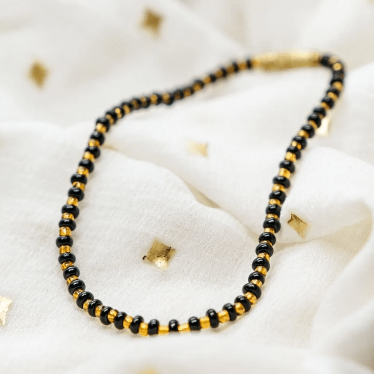 Adjustable Black Golden Beads Nazaria Bracelet featuring evil eye charm, designed for newborns and kids, showcasing a chic black and golden color scheme.