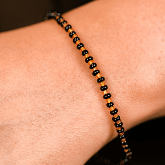 Adjustable Black Golden Beads Nazaria Bracelet featuring evil eye charm, designed for newborns and kids, showcasing a chic black and golden color scheme.