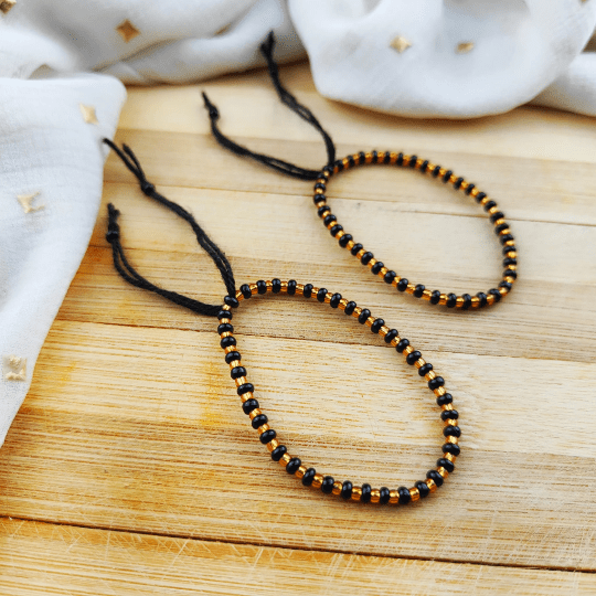 Adjustable Black Golden Beads Nazaria Bracelet featuring evil eye charm, designed for newborns and kids, showcasing a chic black and golden color scheme.