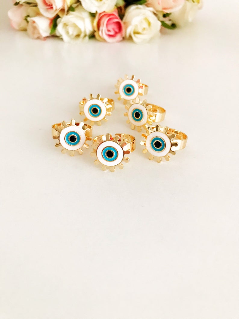 Adjustable Evil Eye Ring featuring a white charm and gold band, symbolizing protection and good luck.