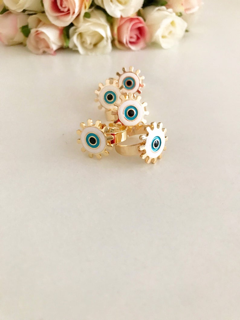 Adjustable Evil Eye Ring featuring a white charm and gold band, symbolizing protection and good luck.