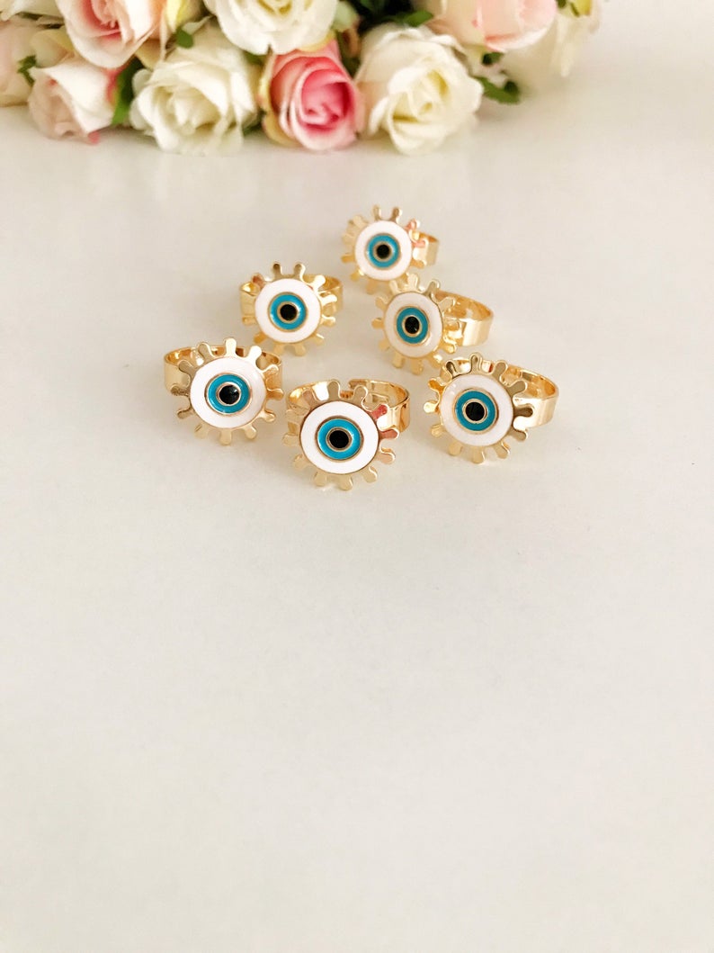 Adjustable Evil Eye Ring featuring a white charm and gold band, symbolizing protection and good luck.