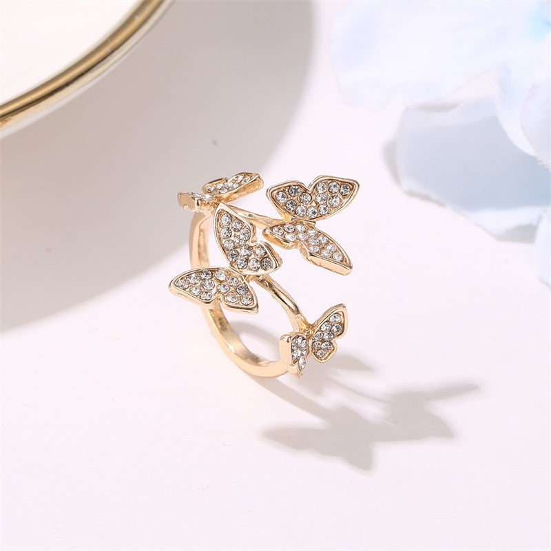 A stylish adjustable ring featuring four intricately designed butterflies made from durable alloy.