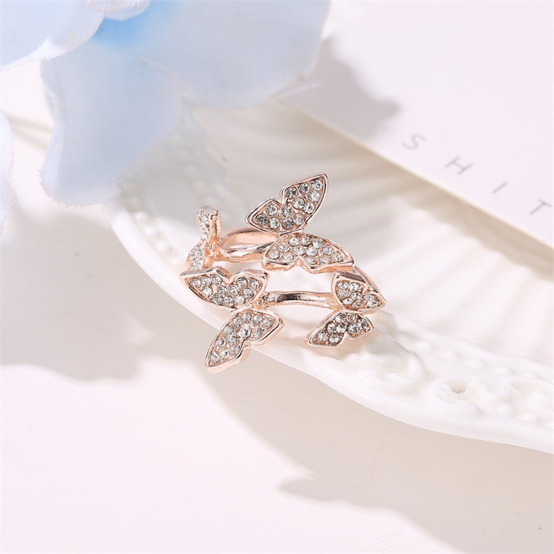 A stylish adjustable ring featuring four intricately designed butterflies made from durable alloy.