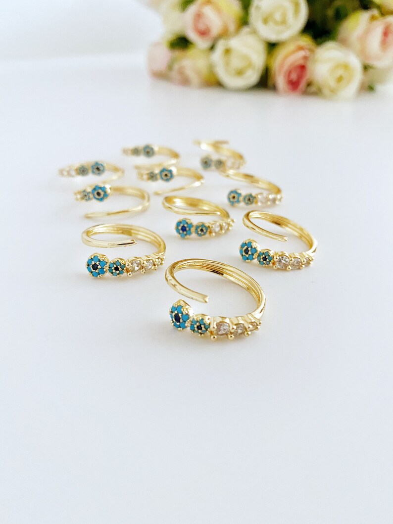 Adjustable gold ring featuring a turquoise bead and evil eye charm, perfect for minimalist jewelry lovers.