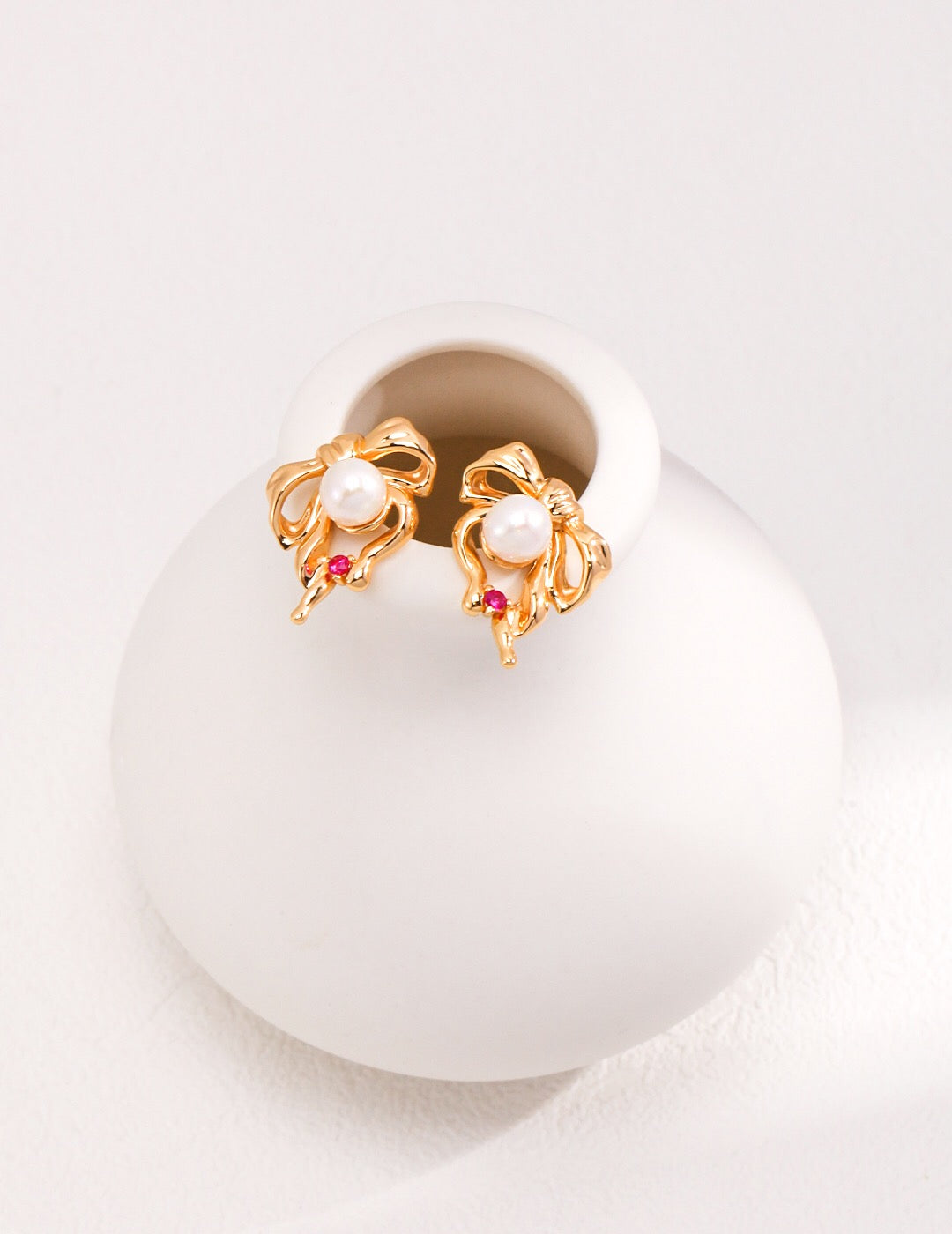 Adorable Bow And Pearl Stud earrings featuring a delicate bow design with a lustrous baroque pearl, crafted from sterling silver and gold vermeil.