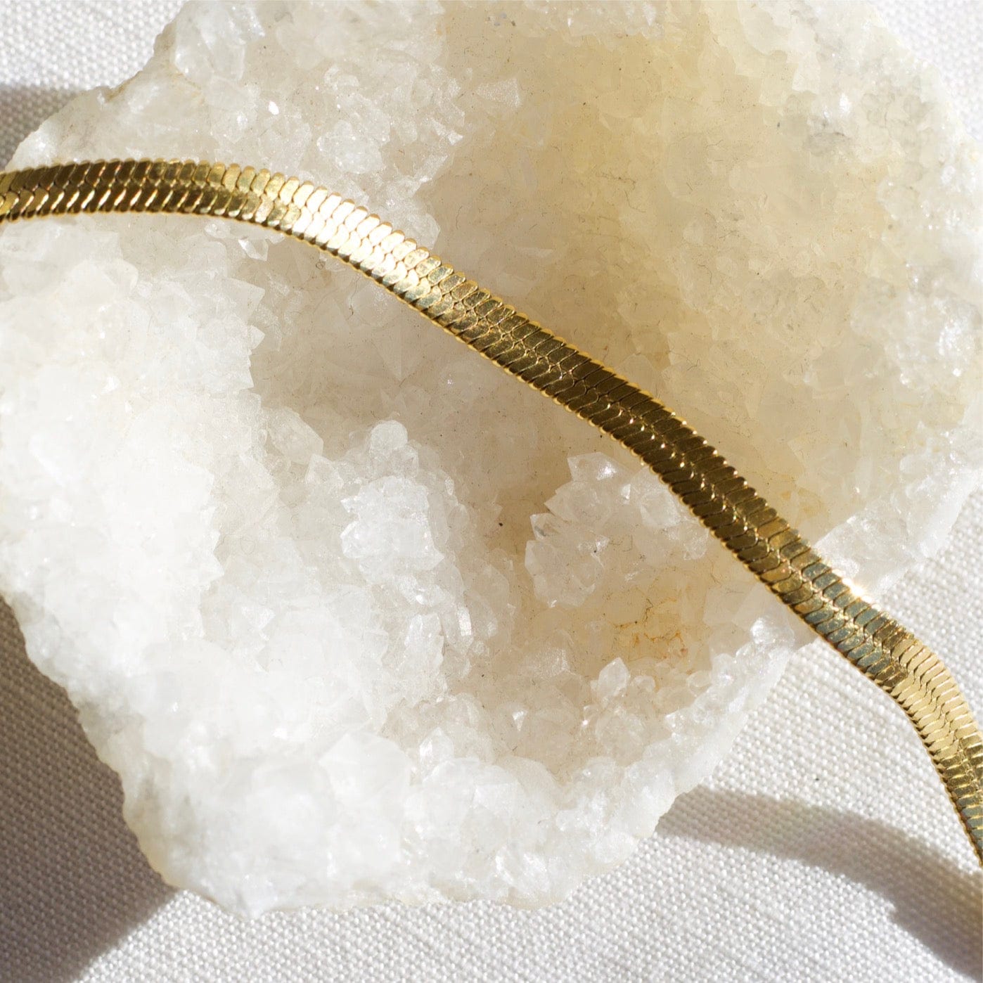 Agapi 4mm Snake Chain Bracelet in rich gold, showcasing its dainty design and adjustable length.