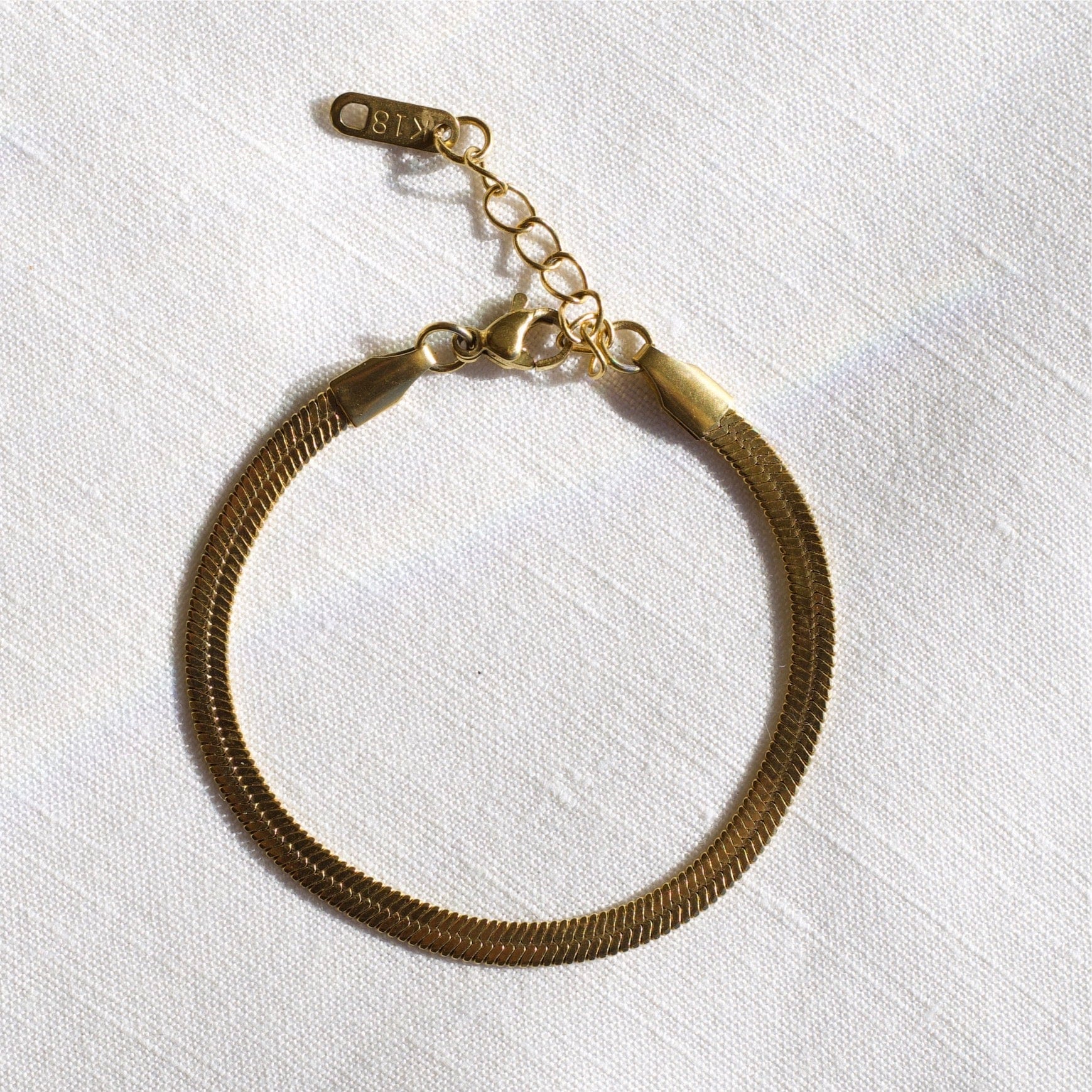 Agapi 4mm Snake Chain Bracelet in rich gold, showcasing its dainty design and adjustable length.