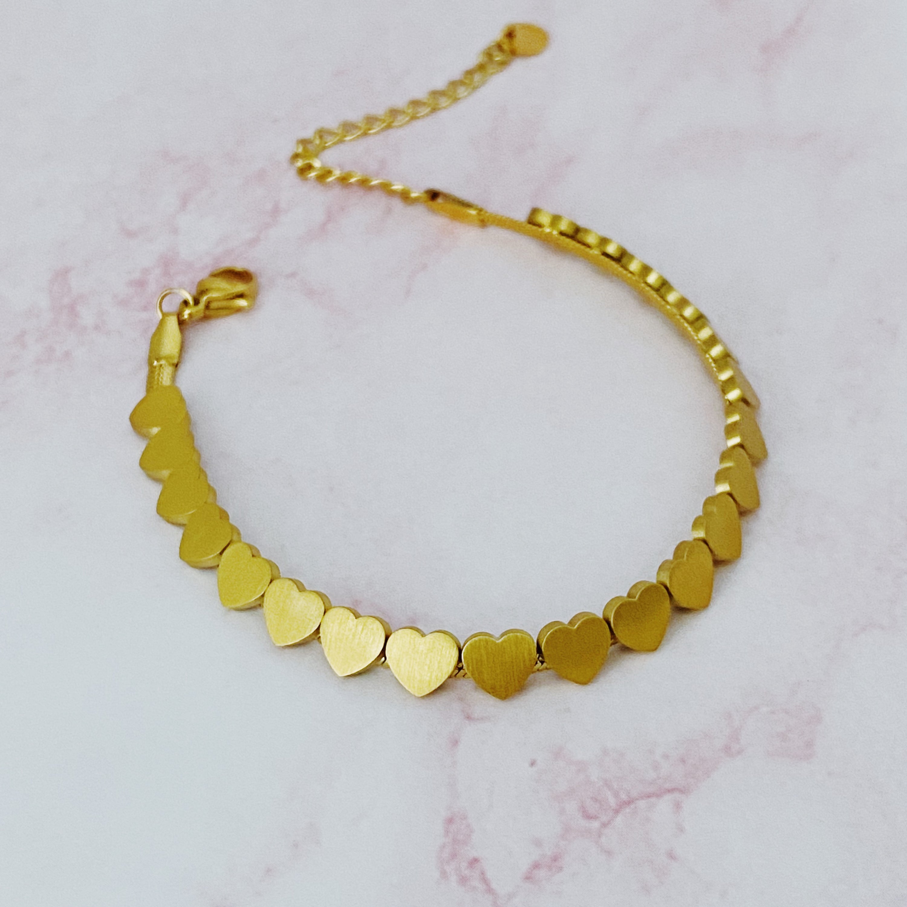 All Around Mini Hearts Bracelet featuring small gold-plated hearts on a delicate chain, showcasing elegance and craftsmanship.