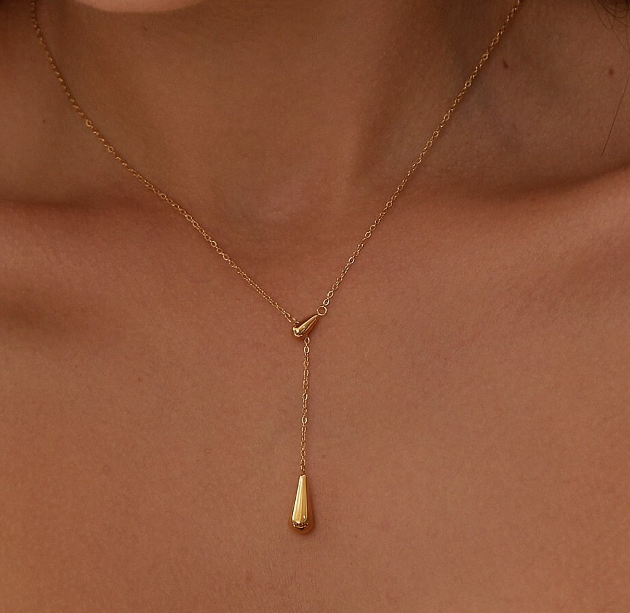 Aaliyah 18K Gold Teardrop Necklace featuring a glossy gold finish and adjustable length, elegantly displayed on a soft background.