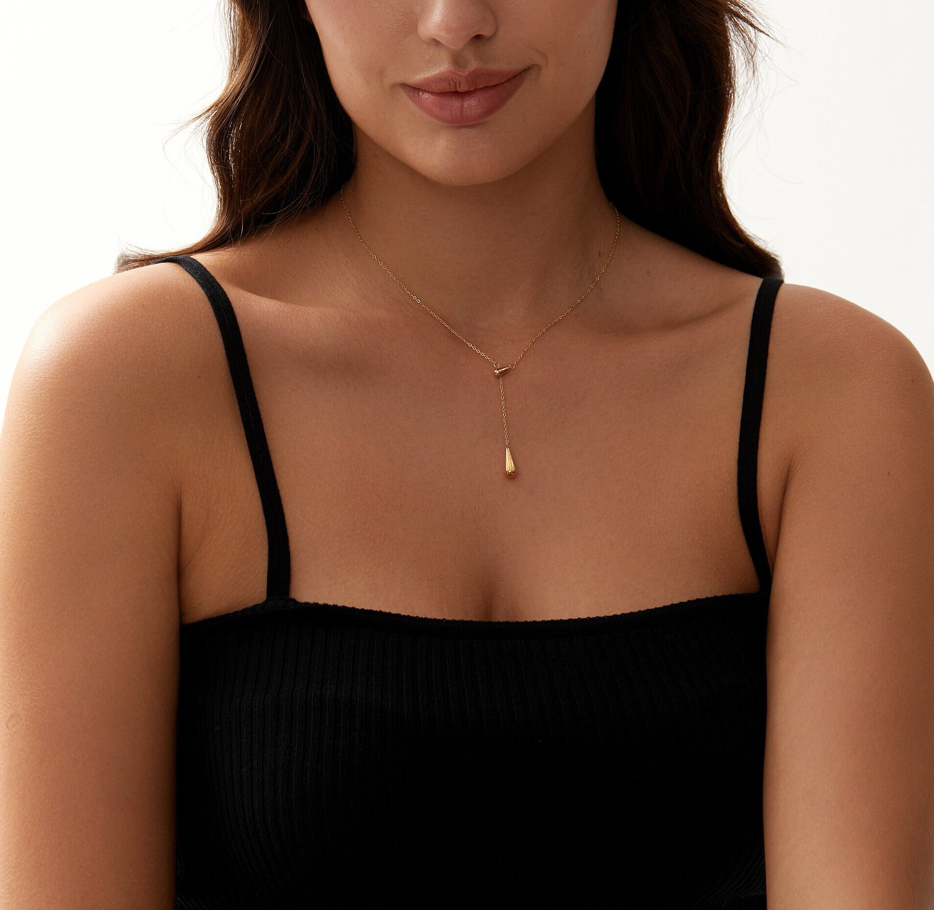 Aaliyah 18K Gold Teardrop Necklace featuring a glossy gold finish and adjustable length, elegantly displayed on a soft background.