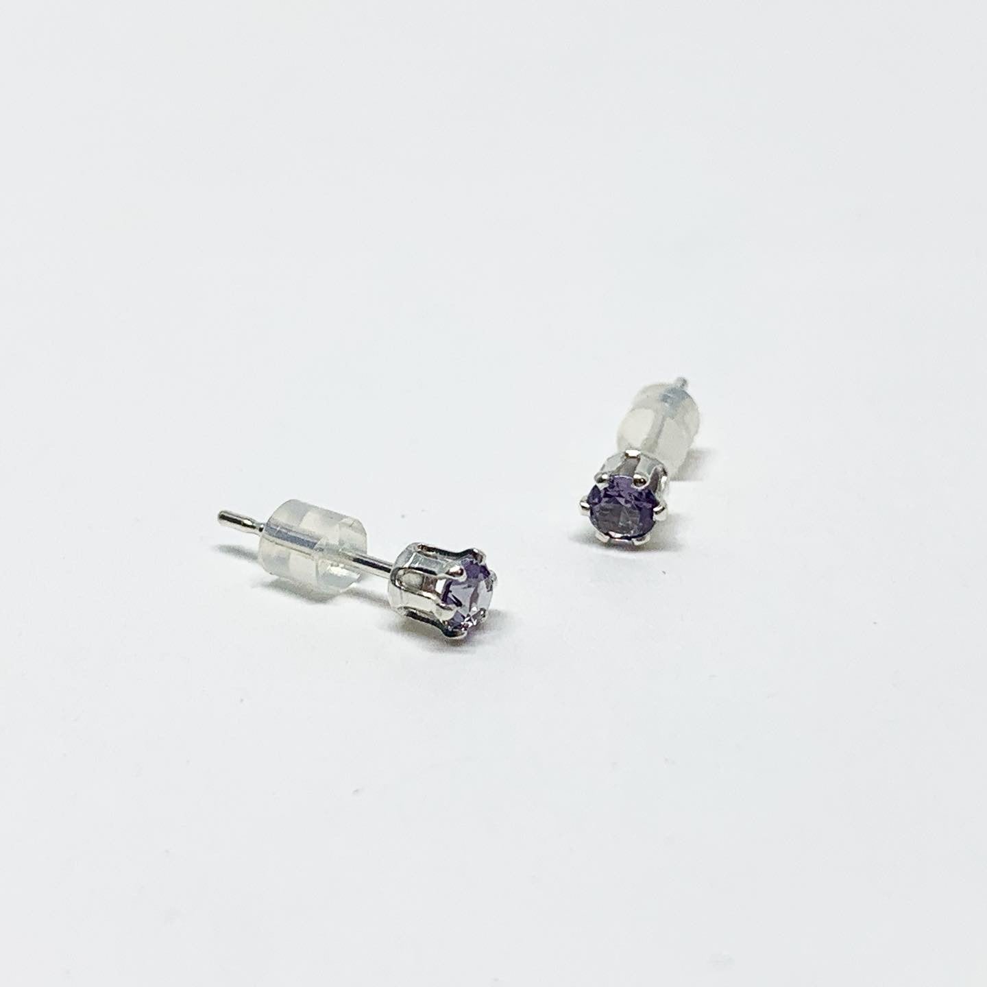 A pair of stunning amethyst birthstone earrings featuring 3mm round faceted lavender gemstones set in sterling silver or yellow gold fill.