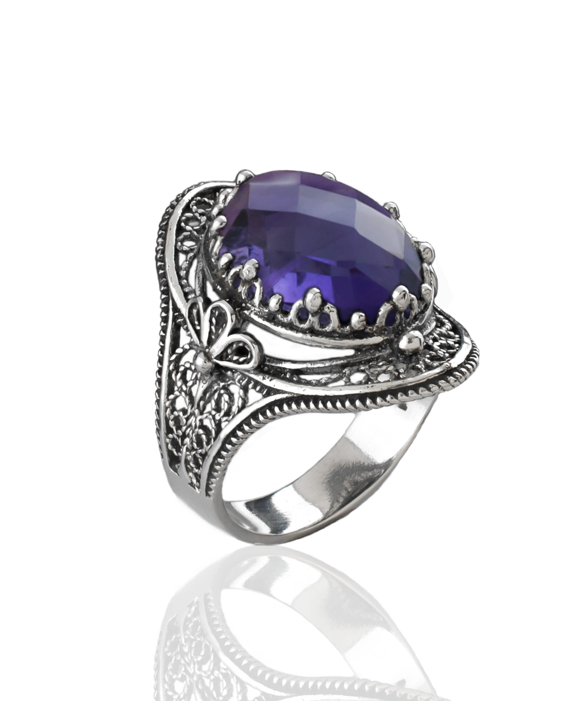 A stunning handmade silver statement ring featuring a double-sided oval cut amethyst gemstone in a delicate filigree design.