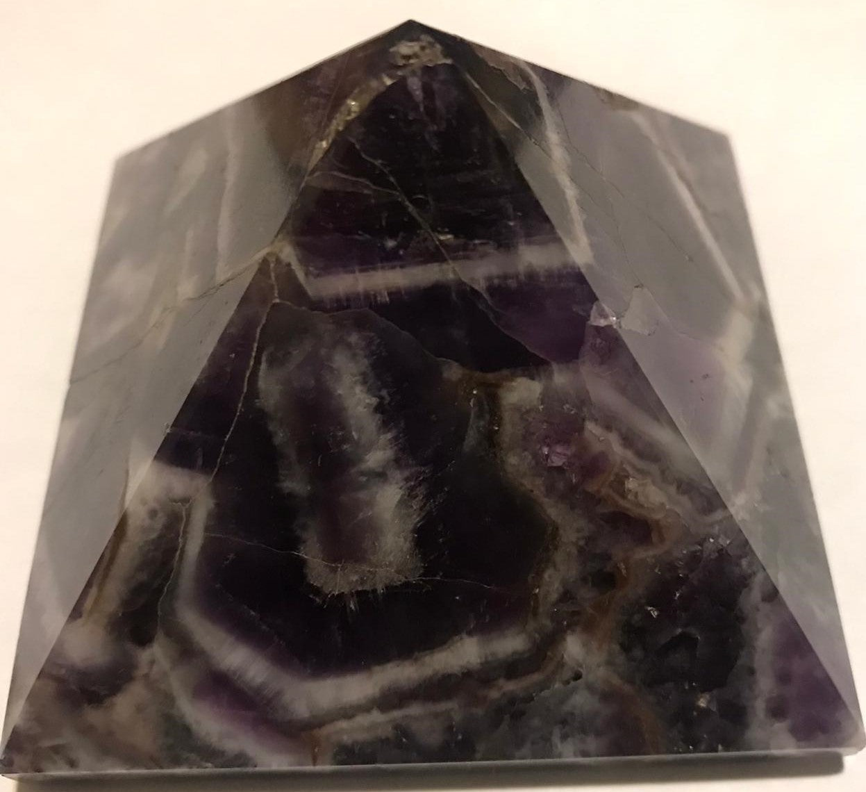 Hand-carved natural Amethyst Pyramid, 3 x 3 inches, showcasing unique color and texture variations.