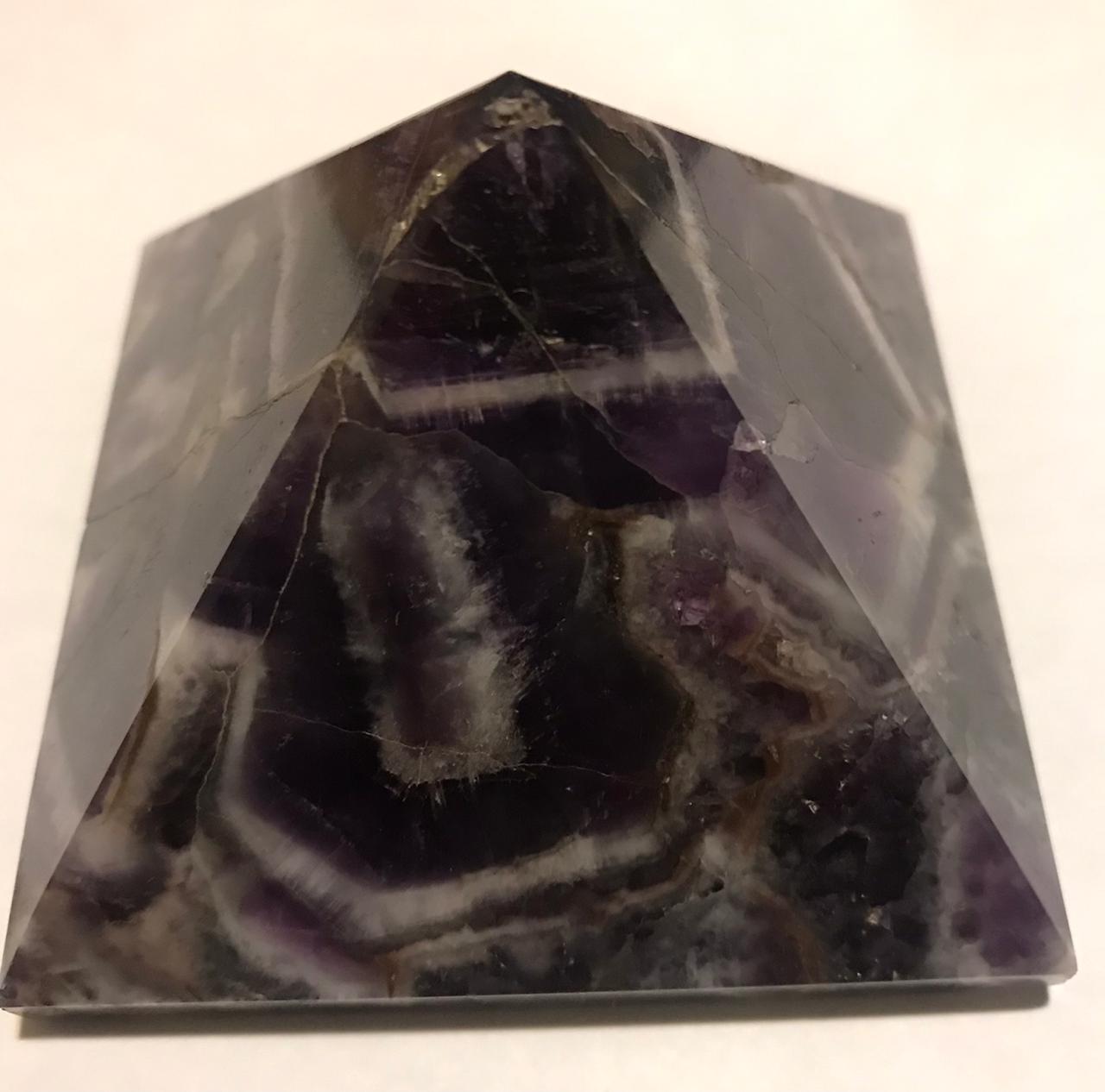 A beautifully hand-carved 50mm Amethyst Pyramid showcasing its rich purple color and unique texture, perfect for home decor and meditation.