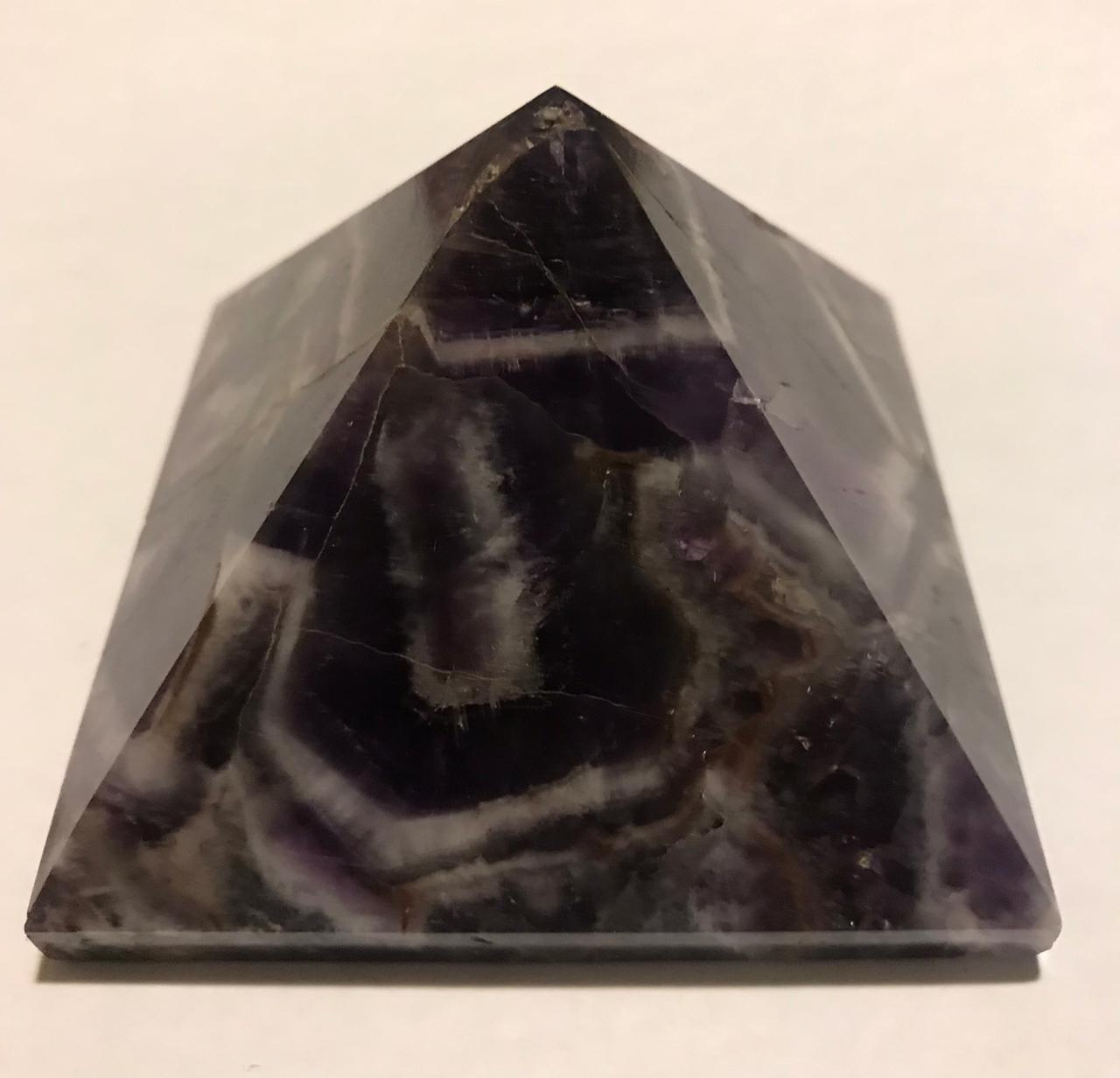 A beautifully hand-carved 50mm Amethyst Pyramid showcasing its rich purple color and unique texture, perfect for home decor and meditation.