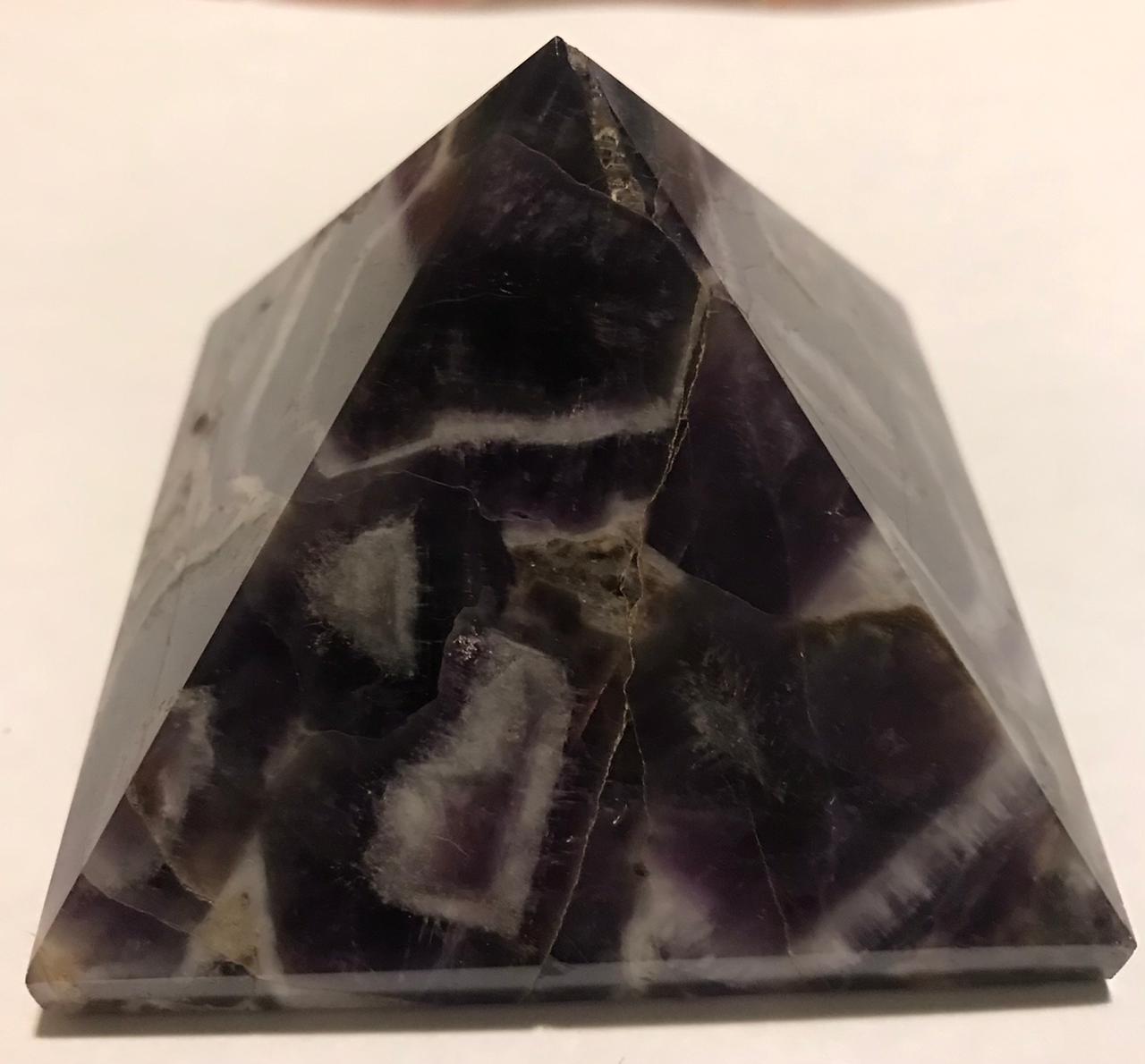 A beautifully hand-carved 50mm Amethyst Pyramid showcasing its rich purple color and unique texture, perfect for home decor and meditation.