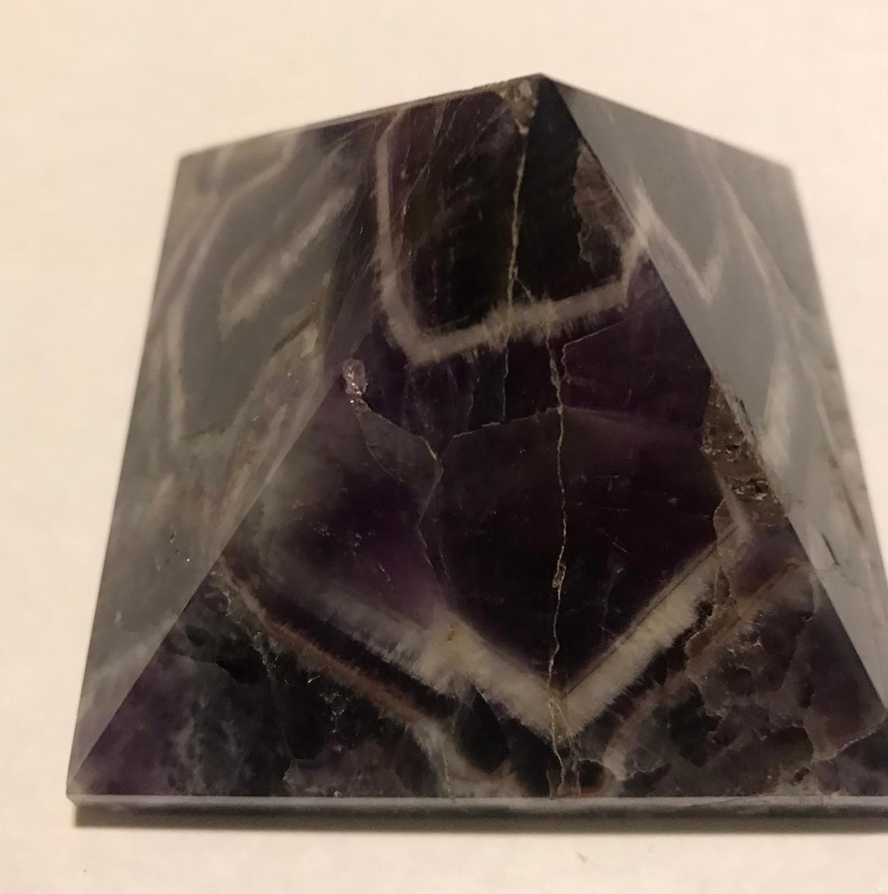 A beautifully hand-carved 50mm Amethyst Pyramid showcasing its rich purple color and unique texture, perfect for home decor and meditation.