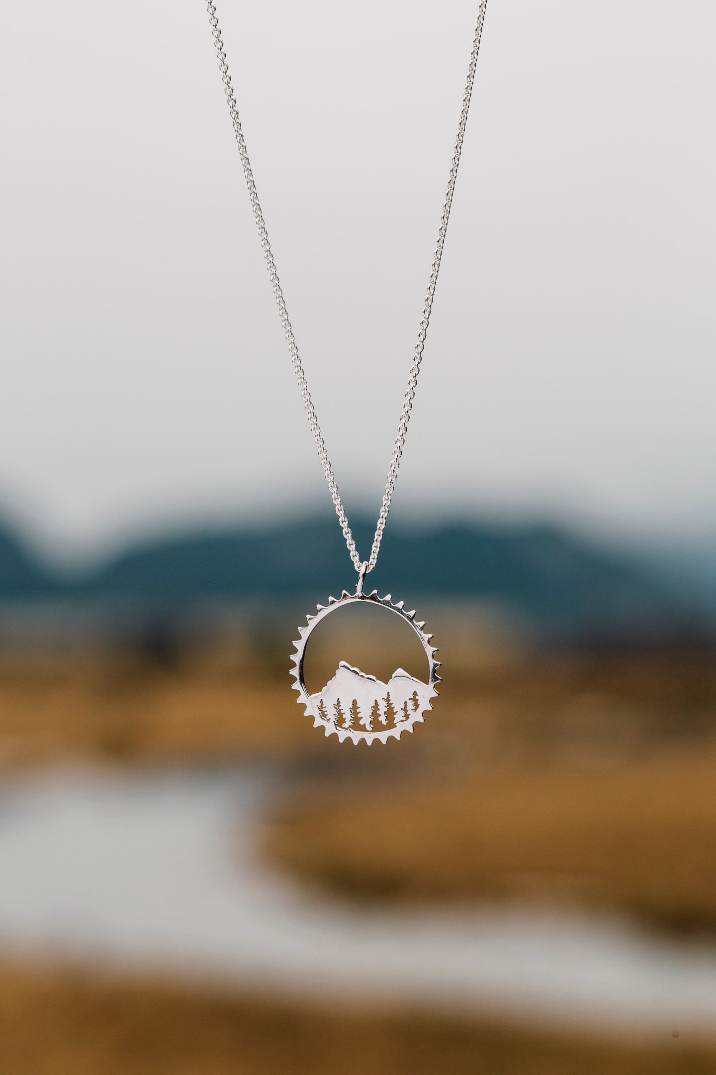 Amore Mountain Necklace featuring a sterling silver mountain design in a chain ring, symbolizing biking adventures.