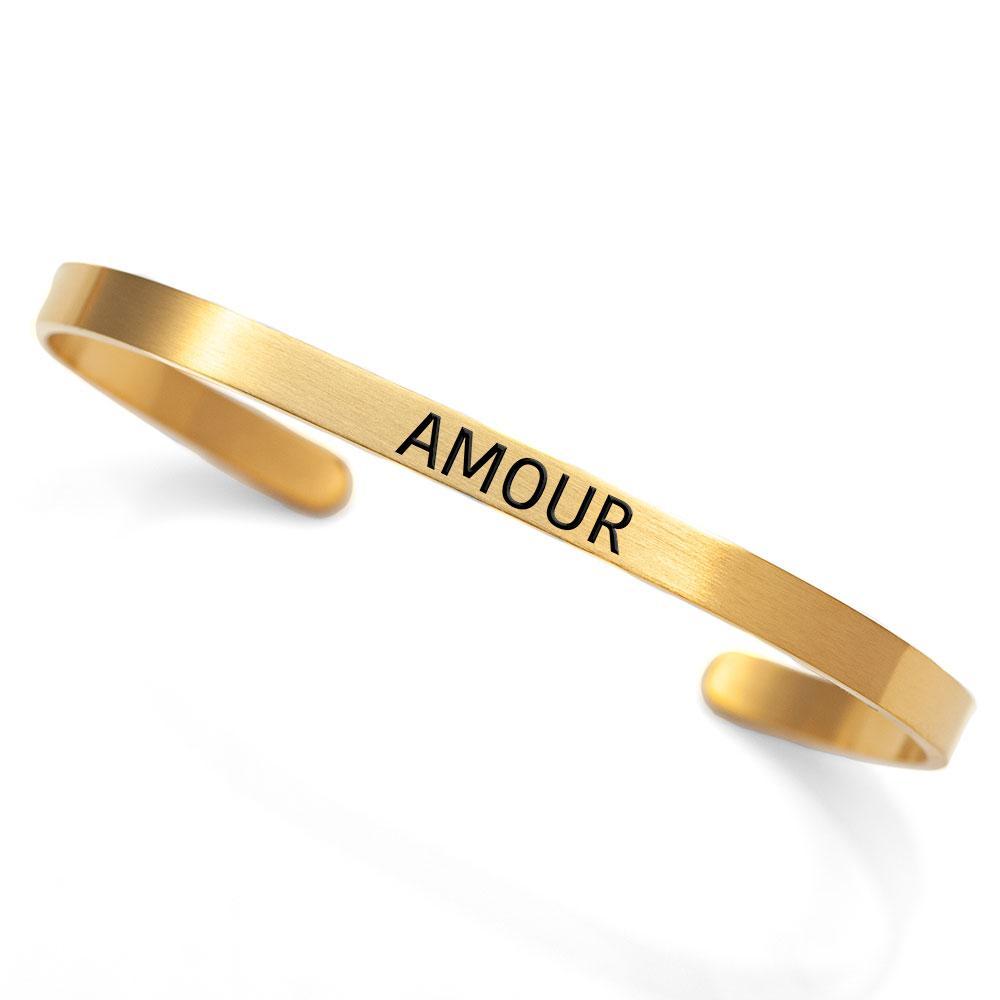 A dainty 'Amour' cuff made of stainless steel with an 18K gold plated finish, elegantly designed to symbolize love.