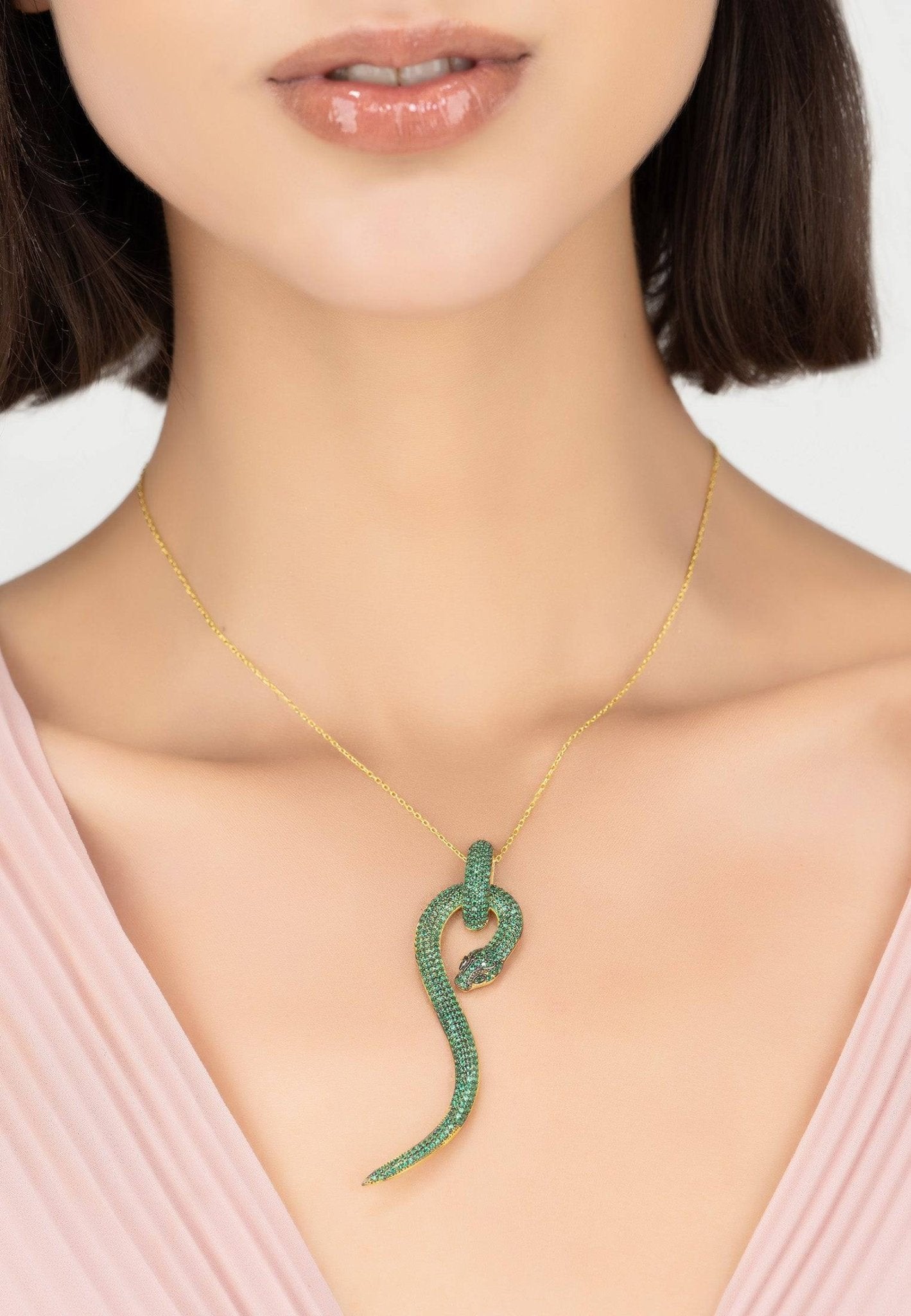 Anaconda Snake Pendant Necklace in gold with emerald zircons, featuring a detailed snake design and adjustable chain.