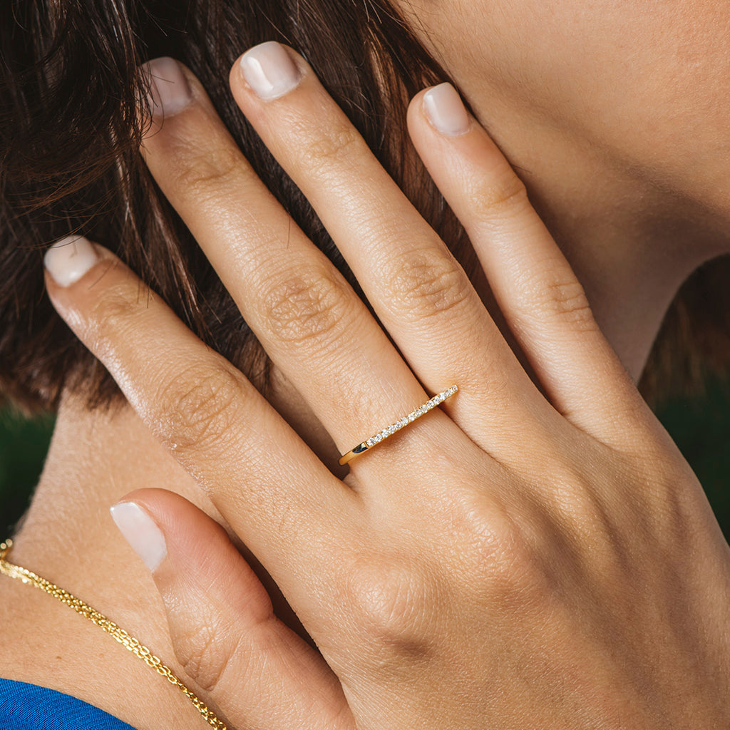 Anillo de plata bañada en oro con circonitas blancas en fila, elegante y moderno.