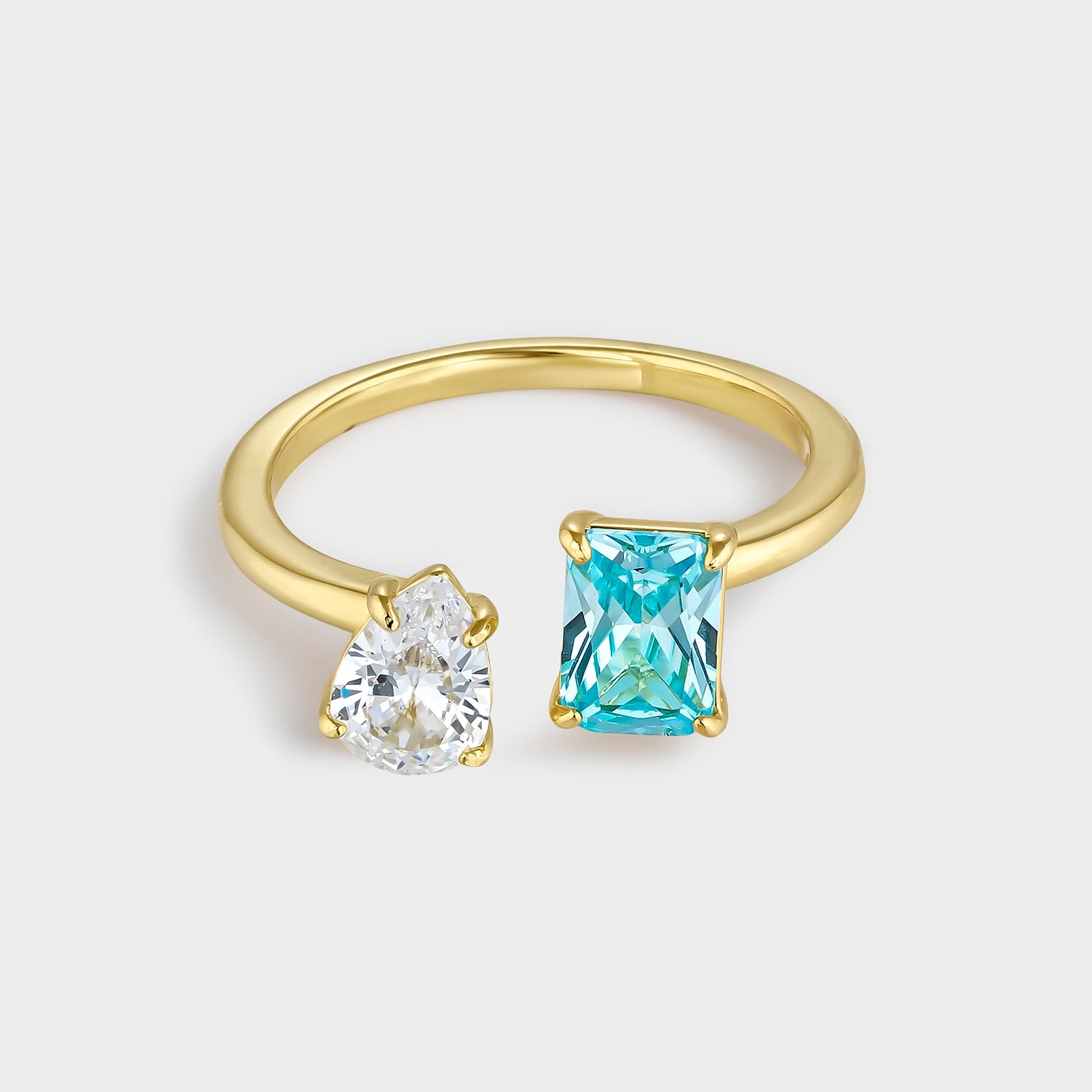 Anillo dúo de circonitas azul y blanca en plata bañada en oro amarillo, con circonita rectangular aguamarina y circonitas blancas brillantes.