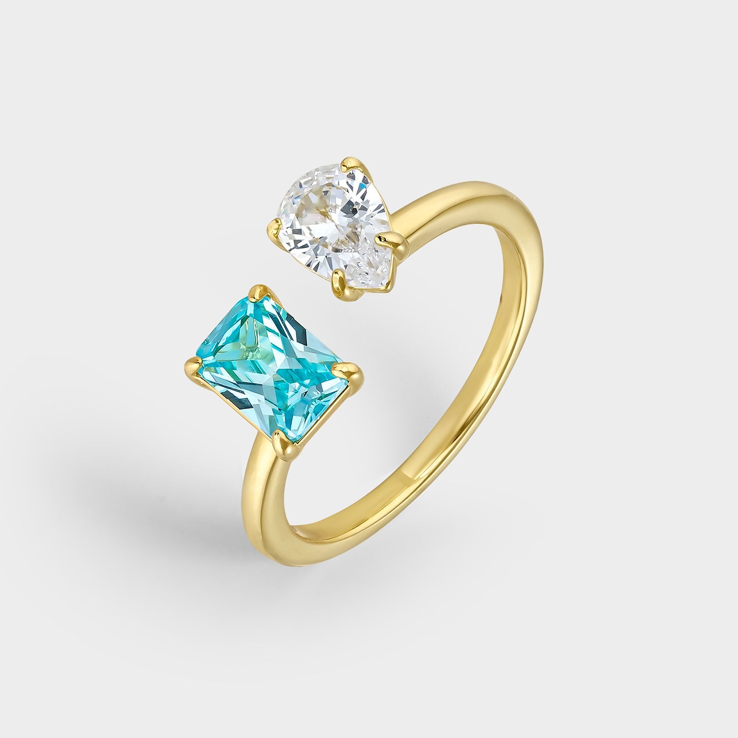 Anillo dúo de circonitas azul y blanca en plata bañada en oro amarillo, con circonita rectangular aguamarina y circonitas blancas brillantes.