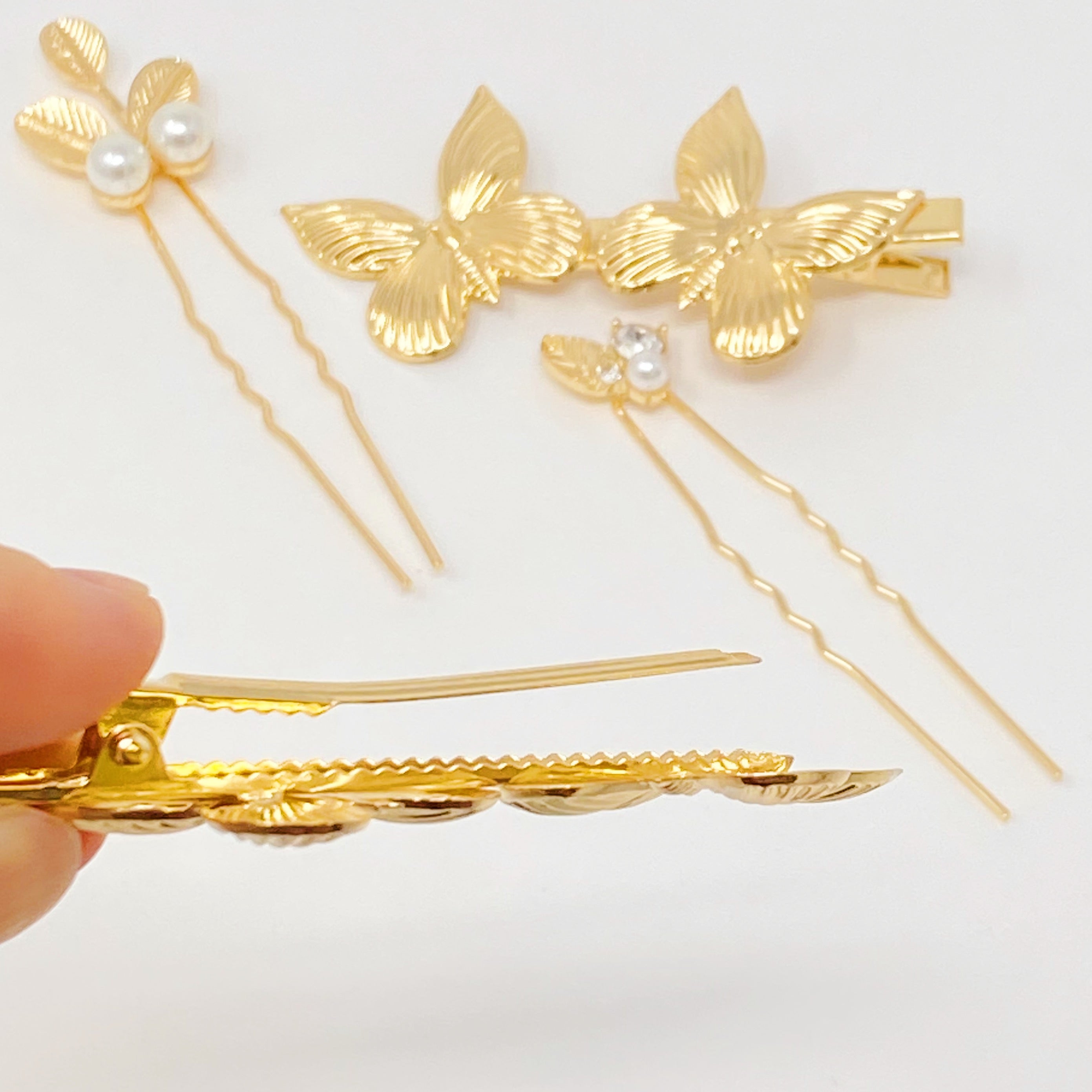 Antique Garden Hair Clip Set featuring two butterfly clips and two elegant pins with a golden finish, showcasing intricate details.