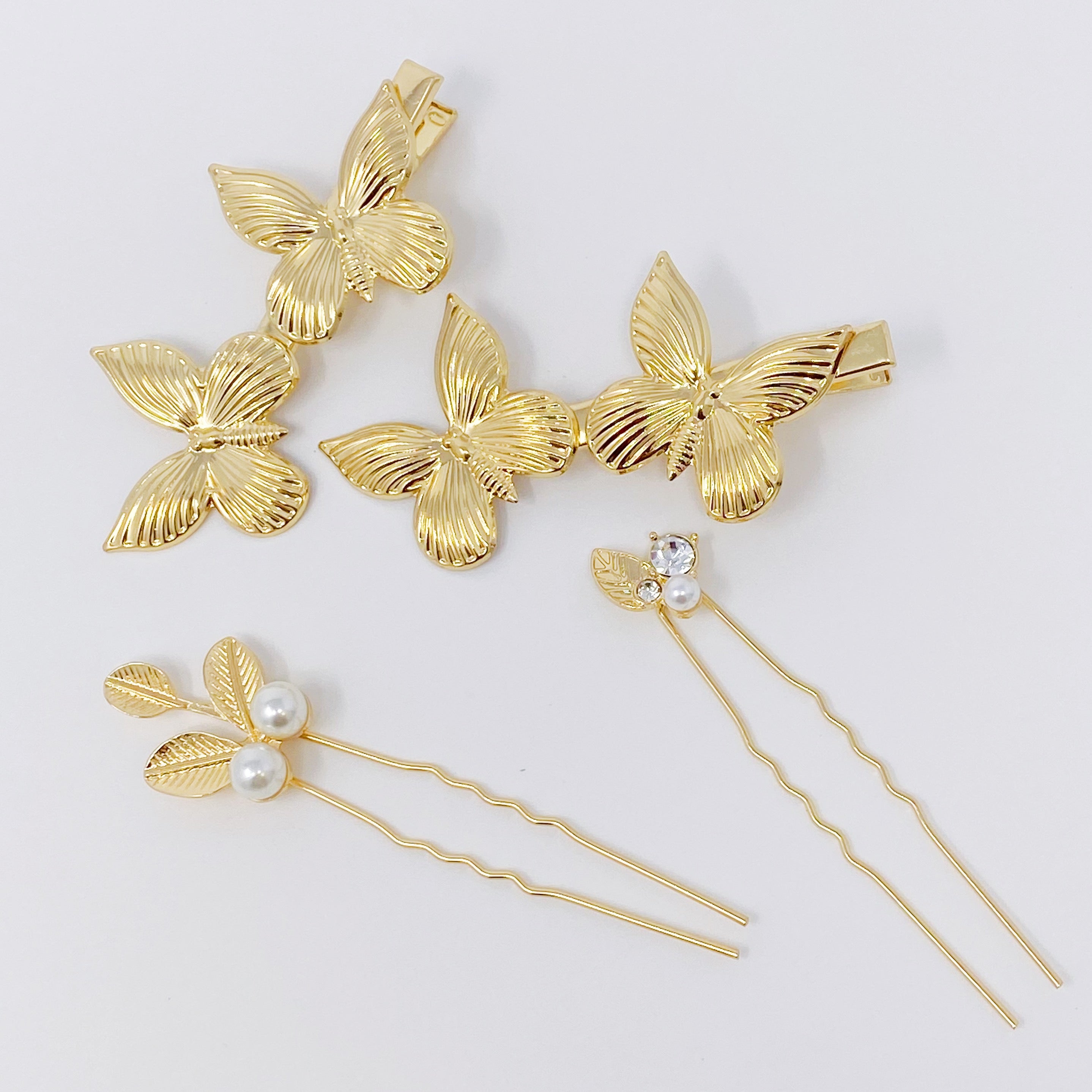 Antique Garden Hair Clip Set featuring two butterfly clips and two elegant pins with a golden finish, showcasing intricate details.