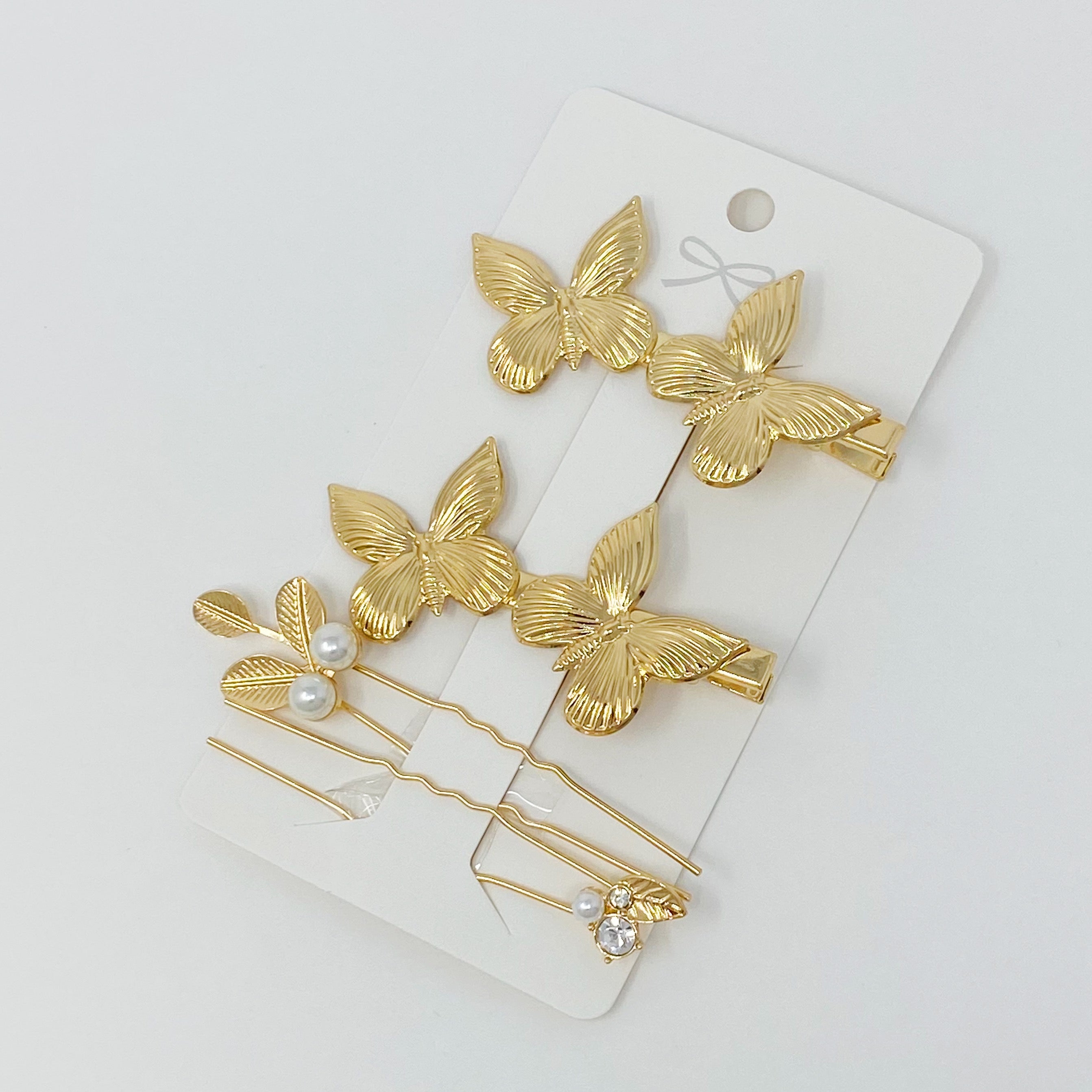 Antique Garden Hair Clip Set featuring two butterfly clips and two elegant pins with a golden finish, showcasing intricate details.