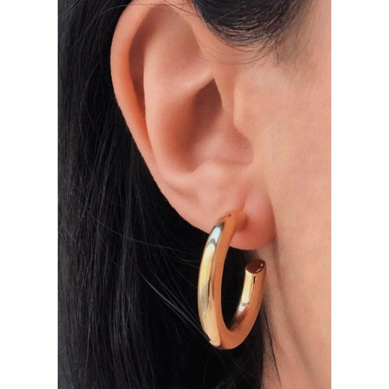 Anya Mini Hoop earrings in 18K gold plated stainless steel with a chic open hoop design, showcasing their elegant cylindrical shape.