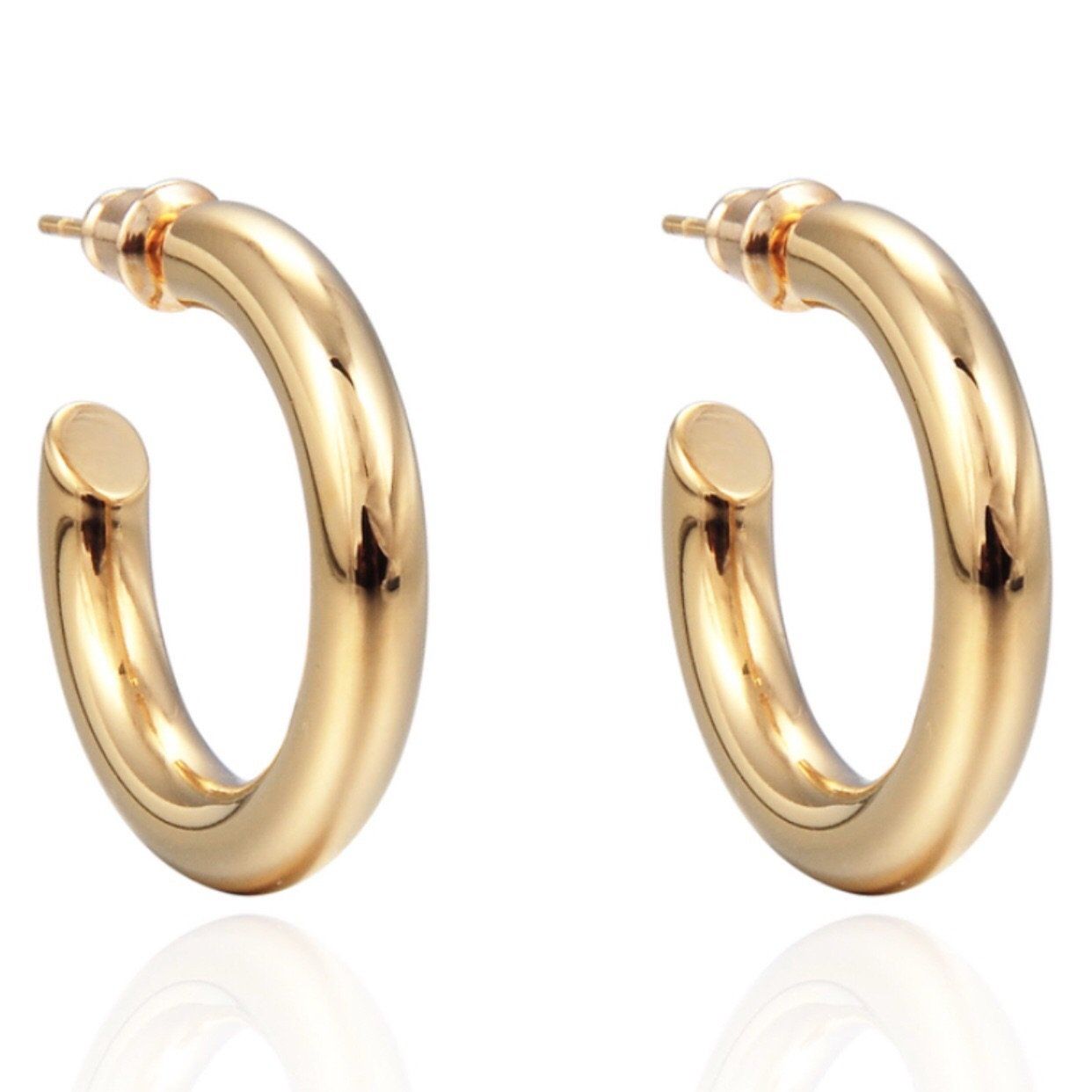 Anya Mini Hoop earrings in 18K gold plated stainless steel with a chic open hoop design, showcasing their elegant cylindrical shape.