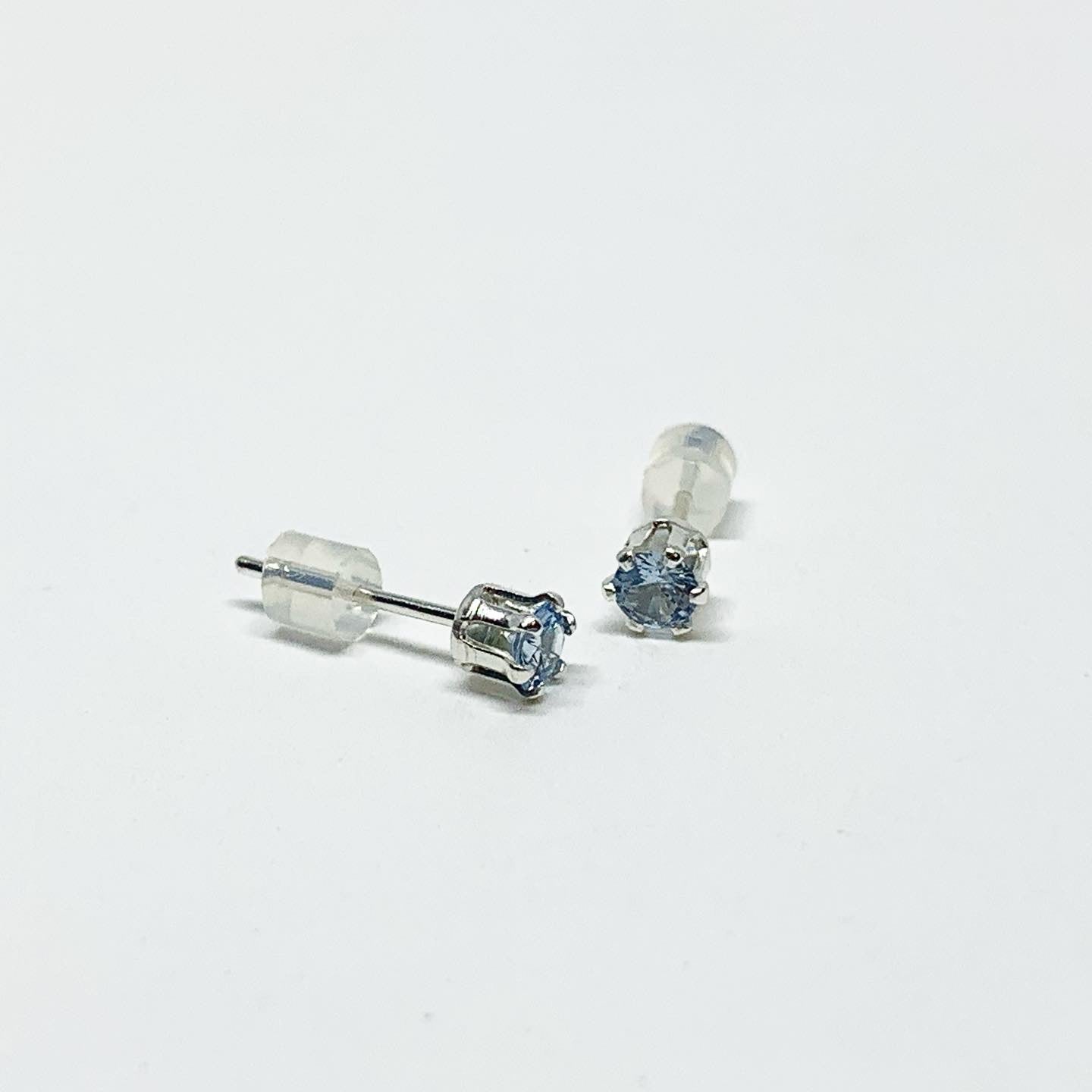 A pair of stunning aquamarine birthstone earrings featuring 3mm round faceted gemstones set in 6 prong studs, available in sterling silver or yellow gold fill.