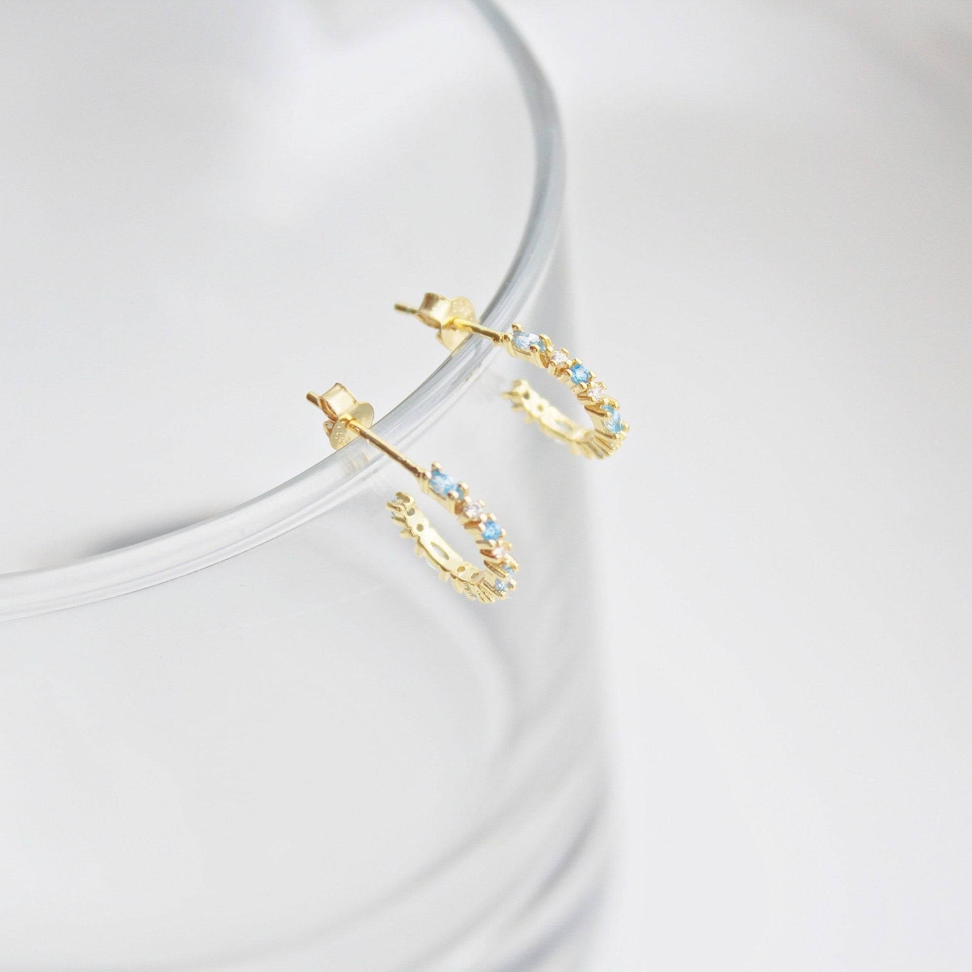 Aquamarine Mini Hoop Earrings featuring sterling silver and gold plating with sparkling blue crystals, elegantly displayed in a gift box.