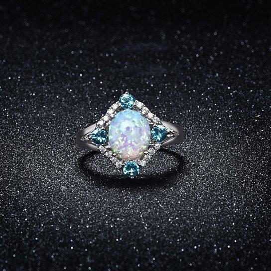 Aquamarine Opal Ring set in 18K white gold with cubic zirconia stones, featuring a halo design.