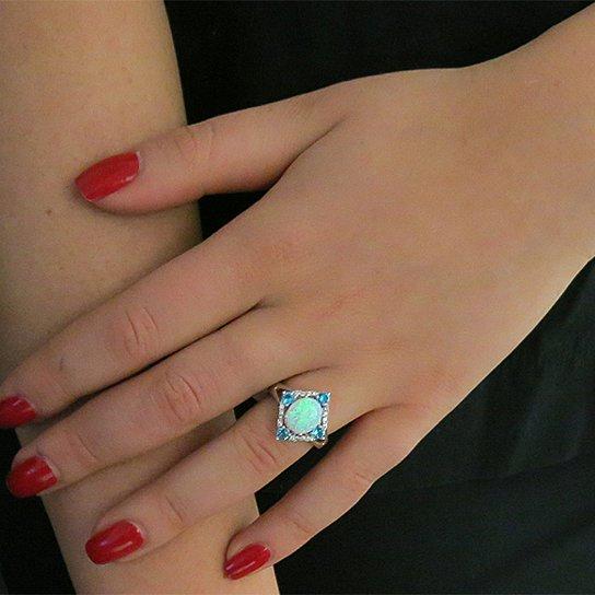 Aquamarine Opal Ring set in 18K white gold with cubic zirconia stones, featuring a halo design.