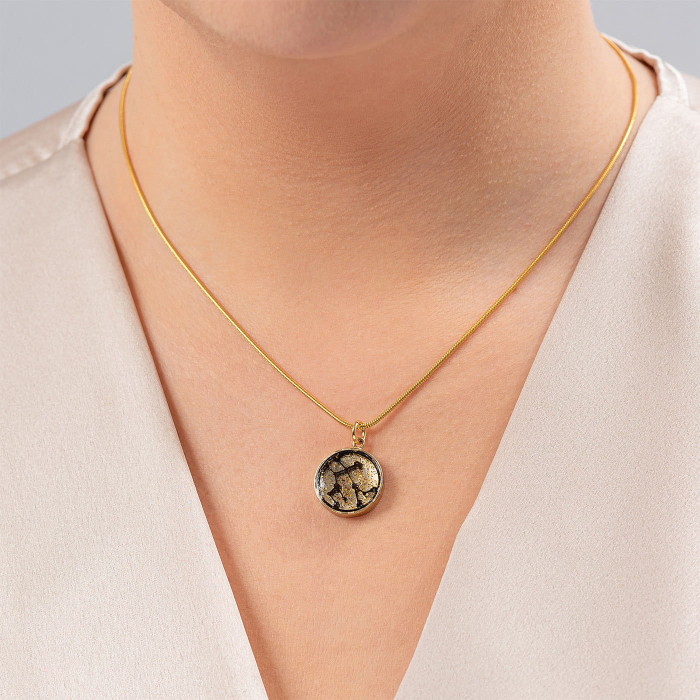 Aquarius Zodiac Sign Sustainable Necklace featuring a gold plated brass pendant with recycled wood and plant resin, elegantly designed and eco-friendly.