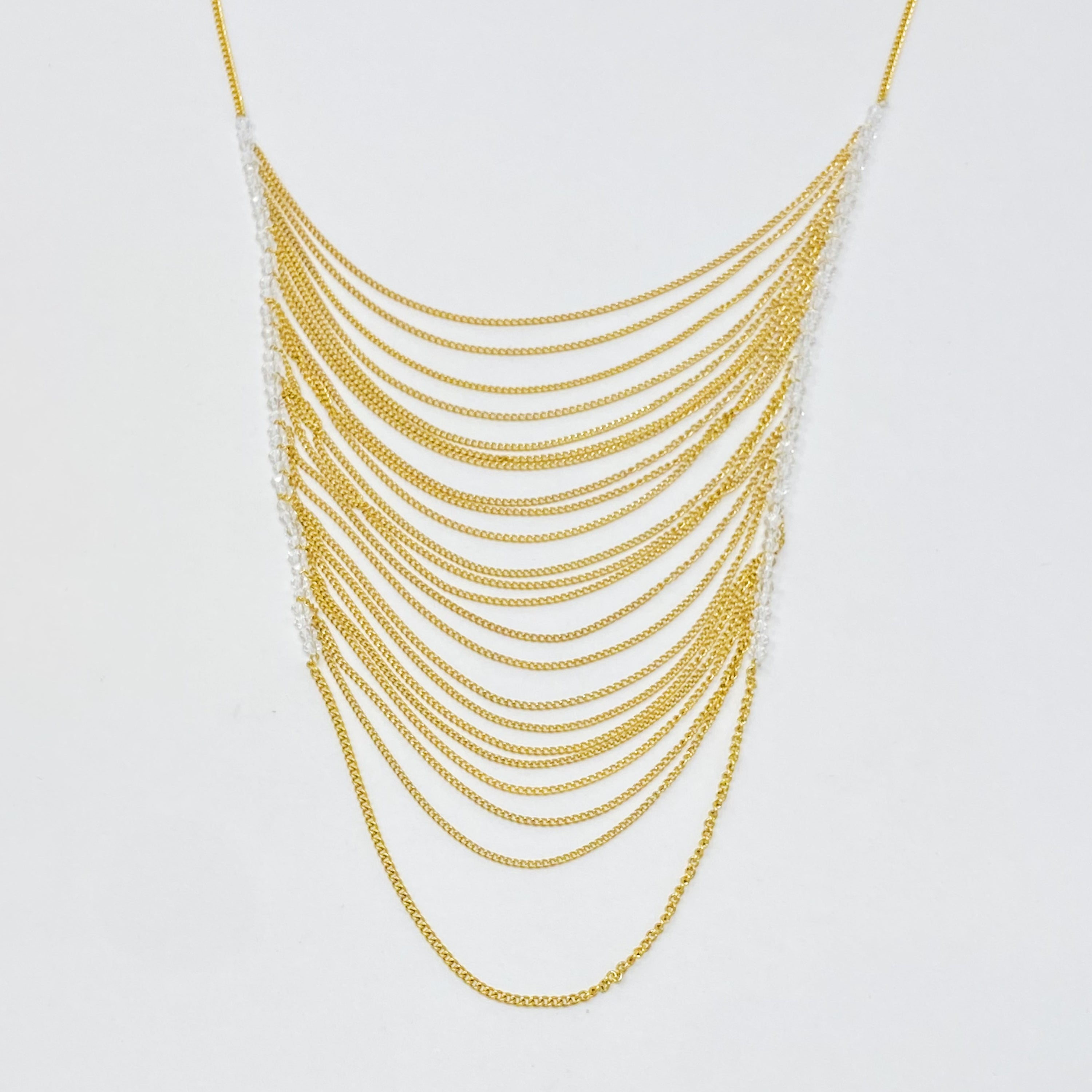 Arched Chain Drop Necklace featuring delicate clear glass beads and 18k gold plated stainless steel chains, elegantly draping down.