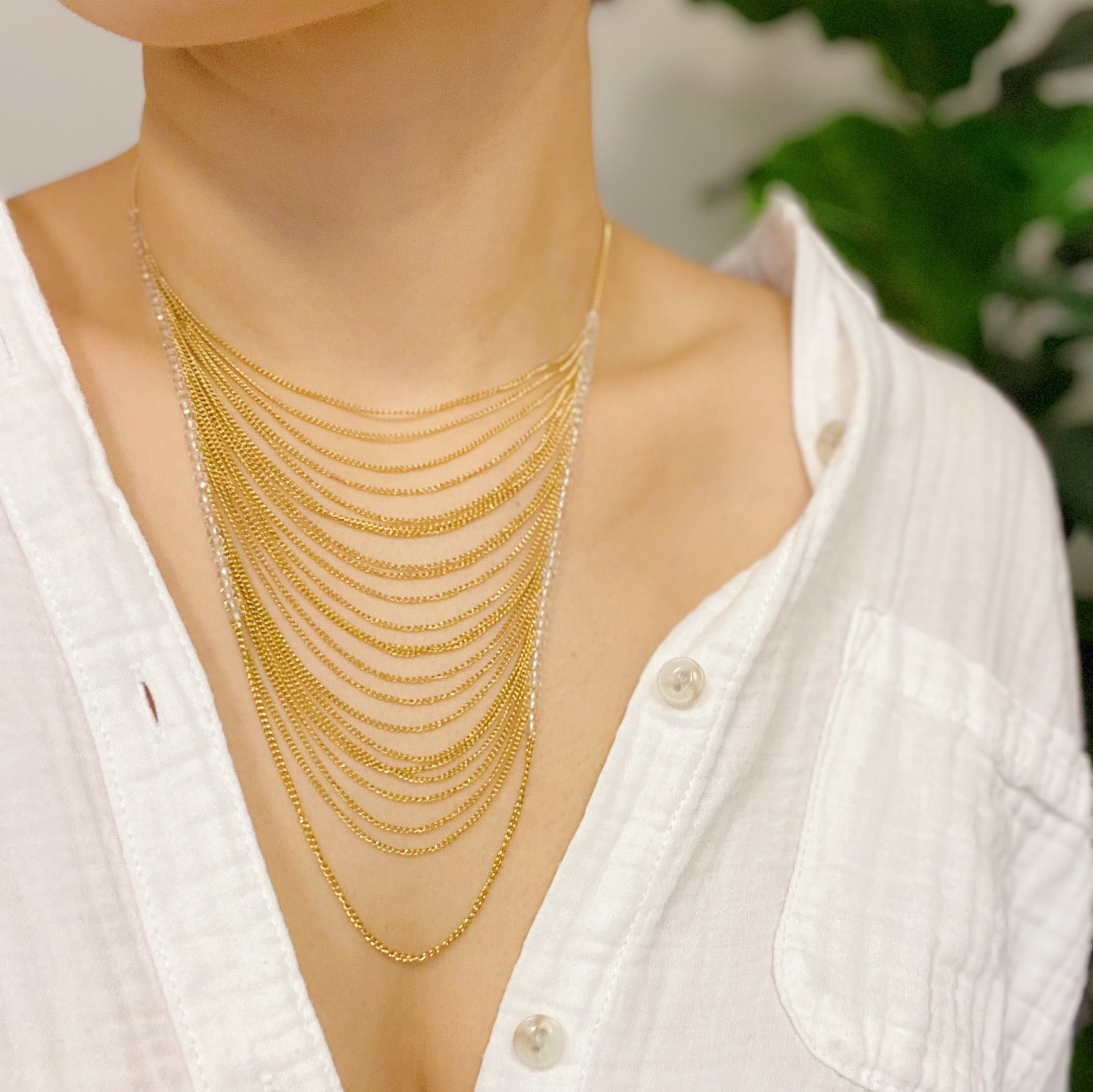 Arched Chain Drop Necklace featuring delicate clear glass beads and 18k gold plated stainless steel chains, elegantly draping down.