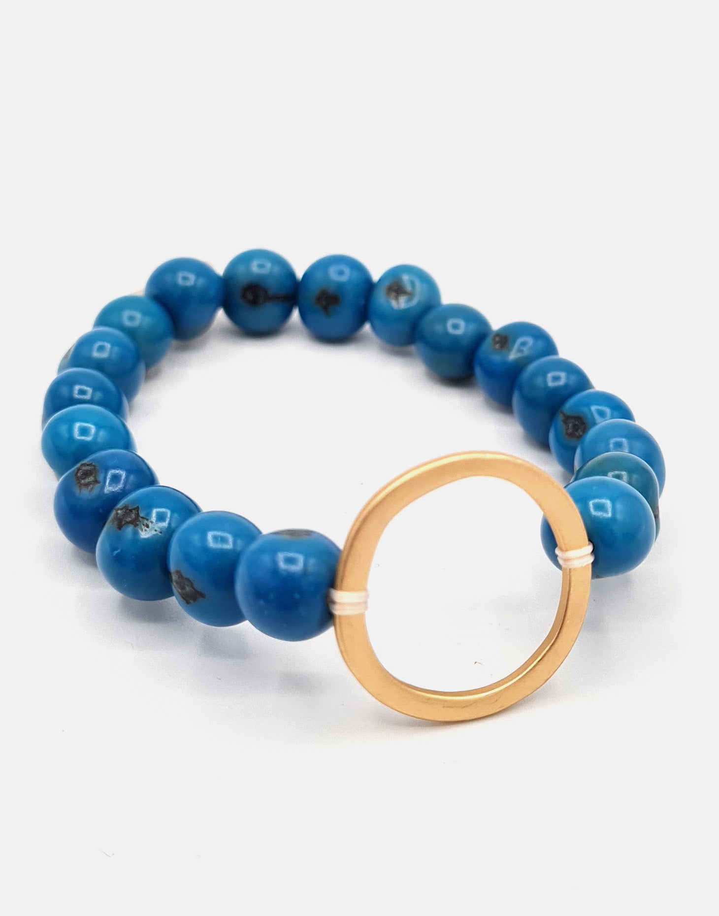 Argola Brass Acai Bracelet in Blue featuring organic Acai seeds and raw Brass hoop detail, showcasing a unique boho style.