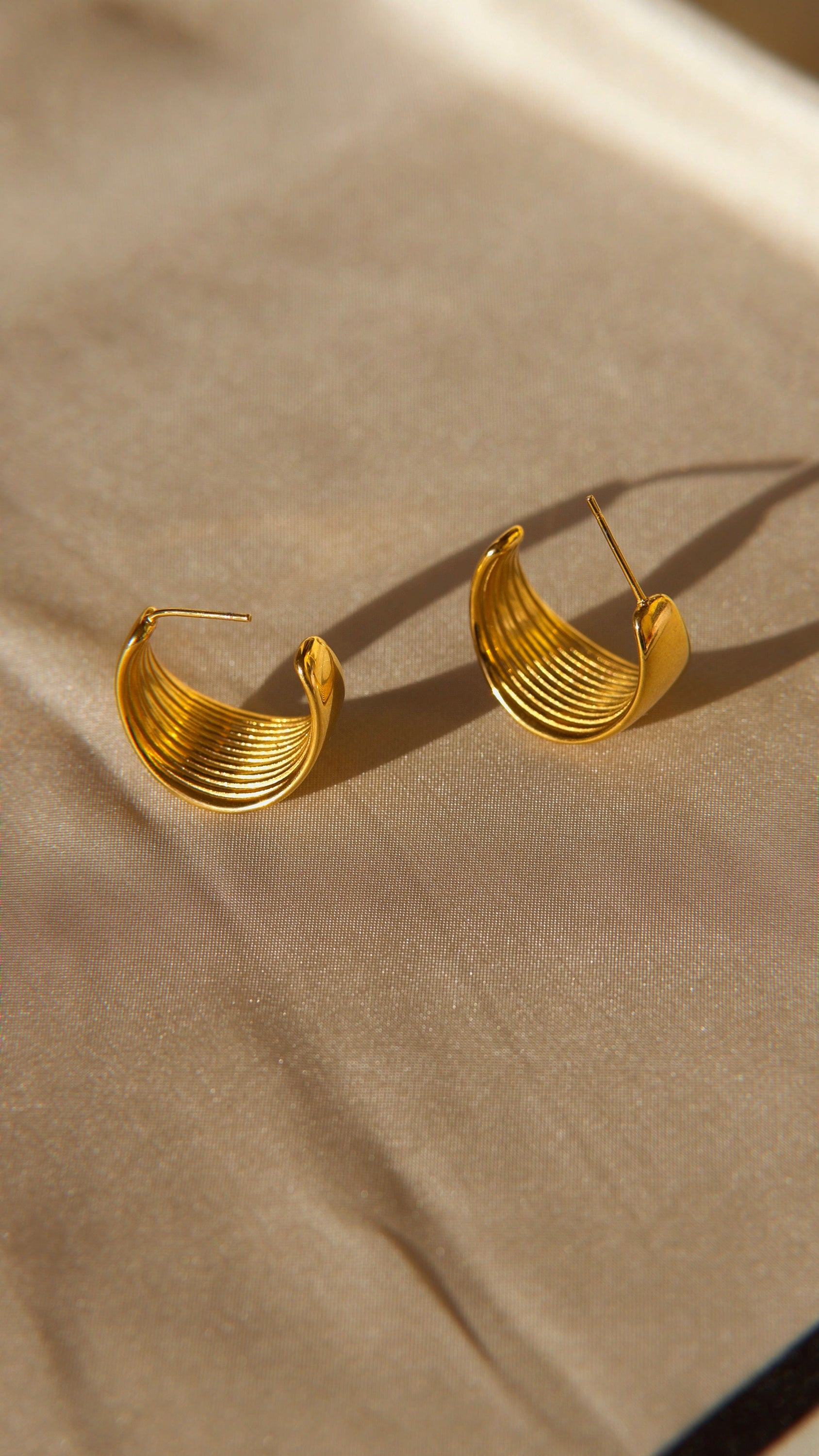 Ariel Luxurious Earrings featuring a bold hoop design in polished stainless steel with 18Kt yellow gold PVD plating.