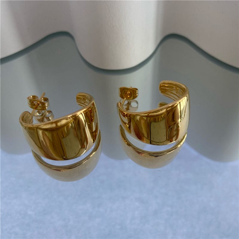 Ariel Luxurious Earrings featuring a bold hoop design in polished stainless steel with 18Kt yellow gold PVD plating.