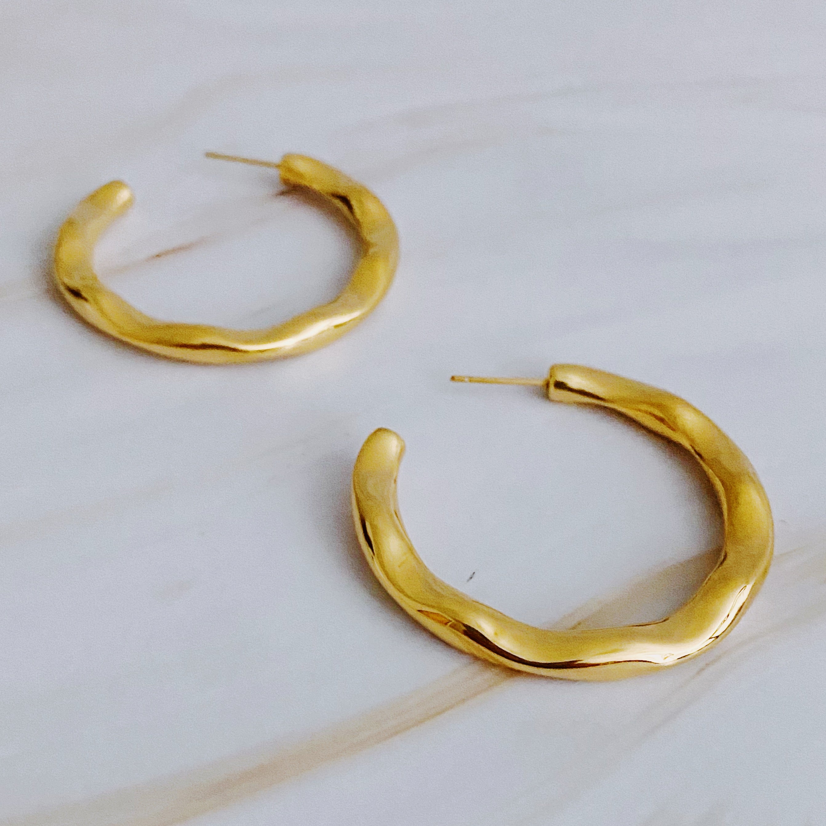 Art In Hoop Earrings featuring a sleek modern design with a unique molten texture, crafted from 18k gold plated stainless steel.