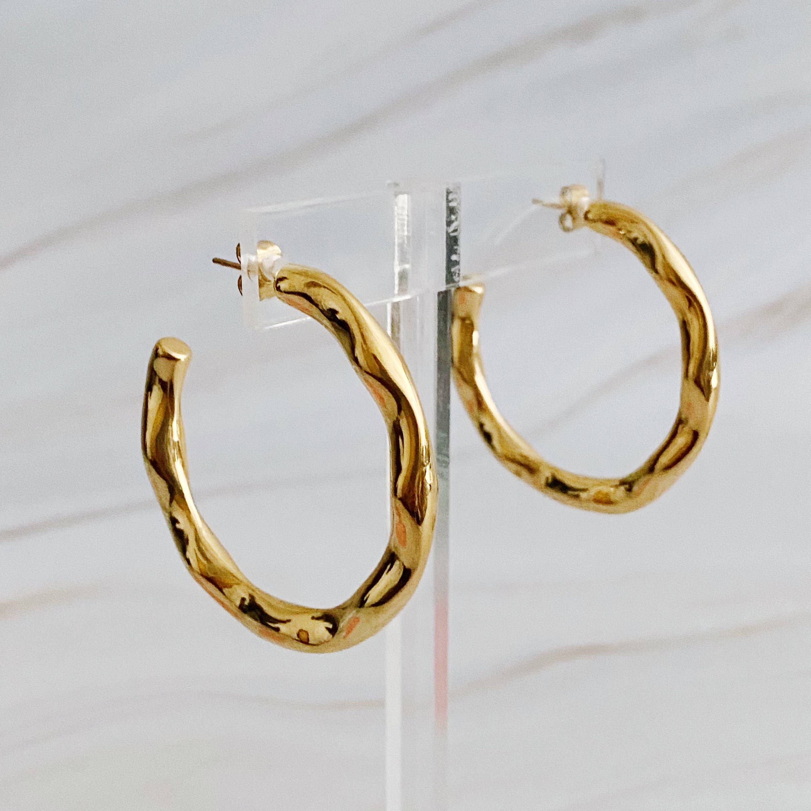 Art In Hoop Earrings featuring a sleek modern design with a unique molten texture, crafted from 18k gold plated stainless steel.