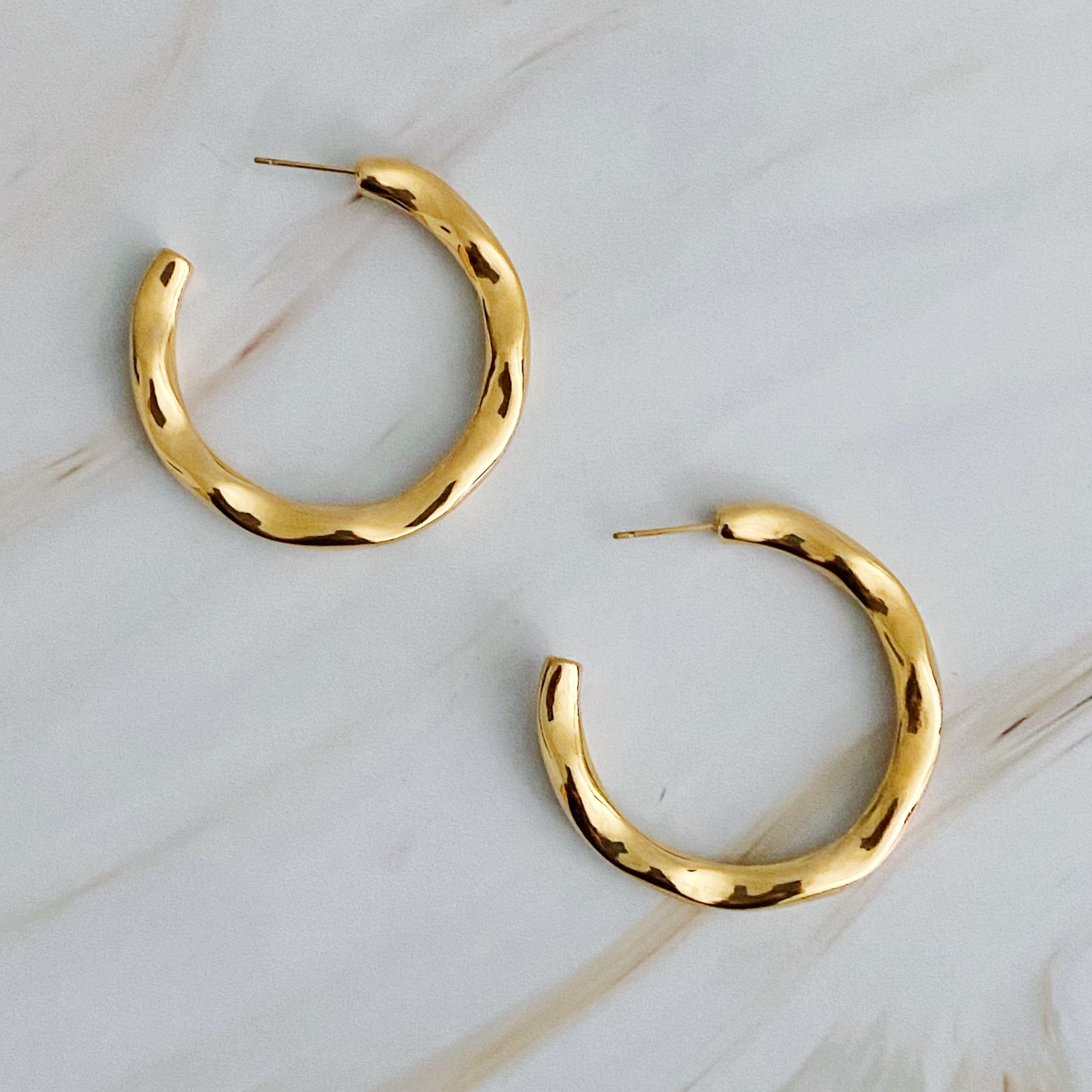 Art In Hoop Earrings featuring a sleek modern design with a unique molten texture, crafted from 18k gold plated stainless steel.