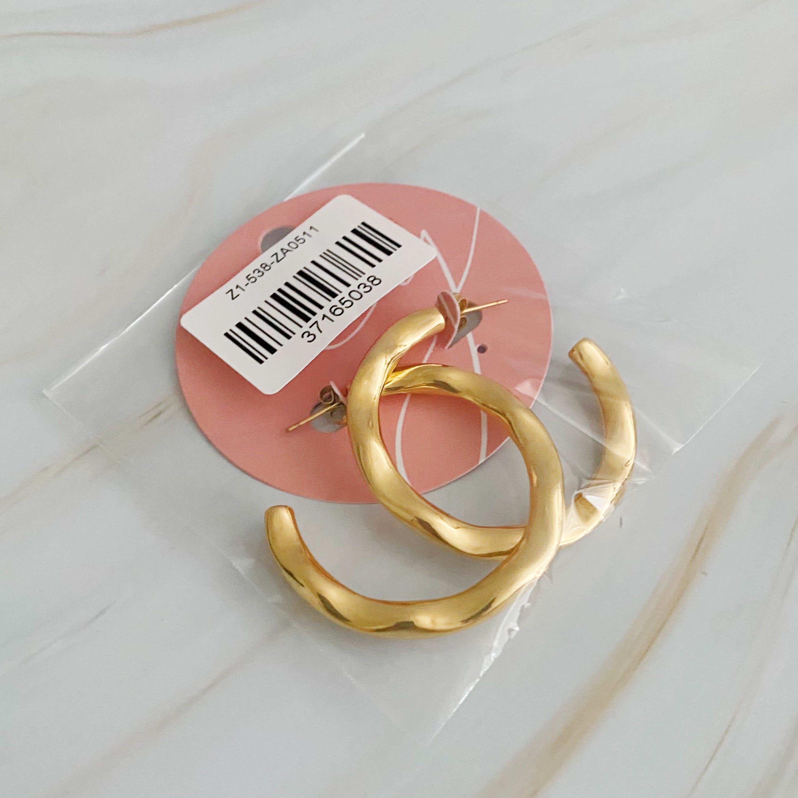 Art In Hoop Earrings featuring a sleek modern design with a unique molten texture, crafted from 18k gold plated stainless steel.