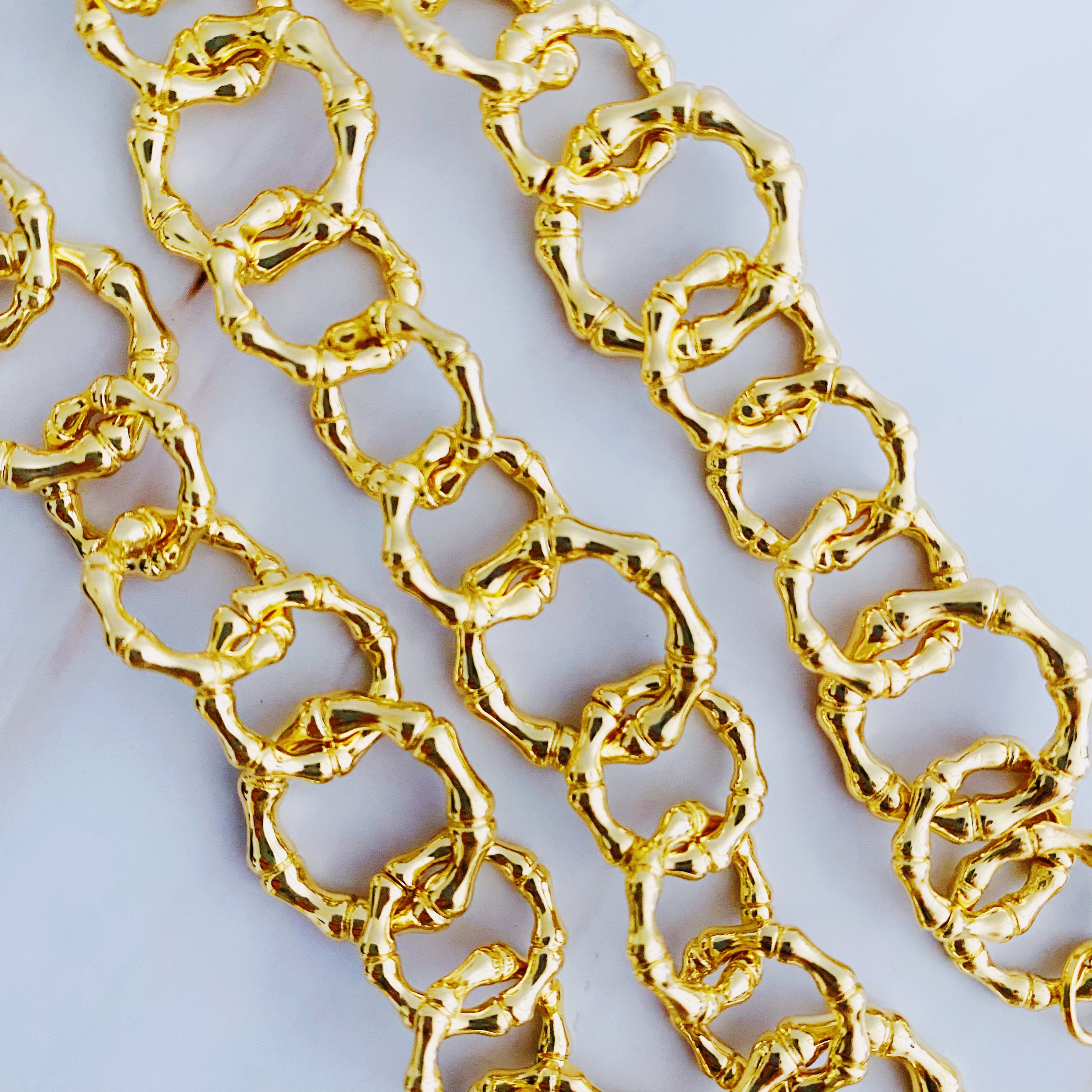 Artfully Linked Chain Necklace featuring varying link sizes and a polished gold finish, elegantly displayed against a soft background.